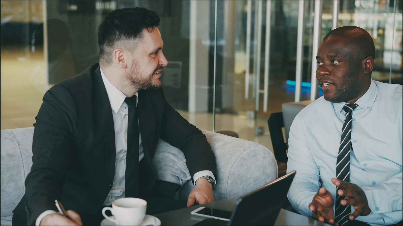 Two people talking over coffee, the way a founder might brief a local reporter on a story.