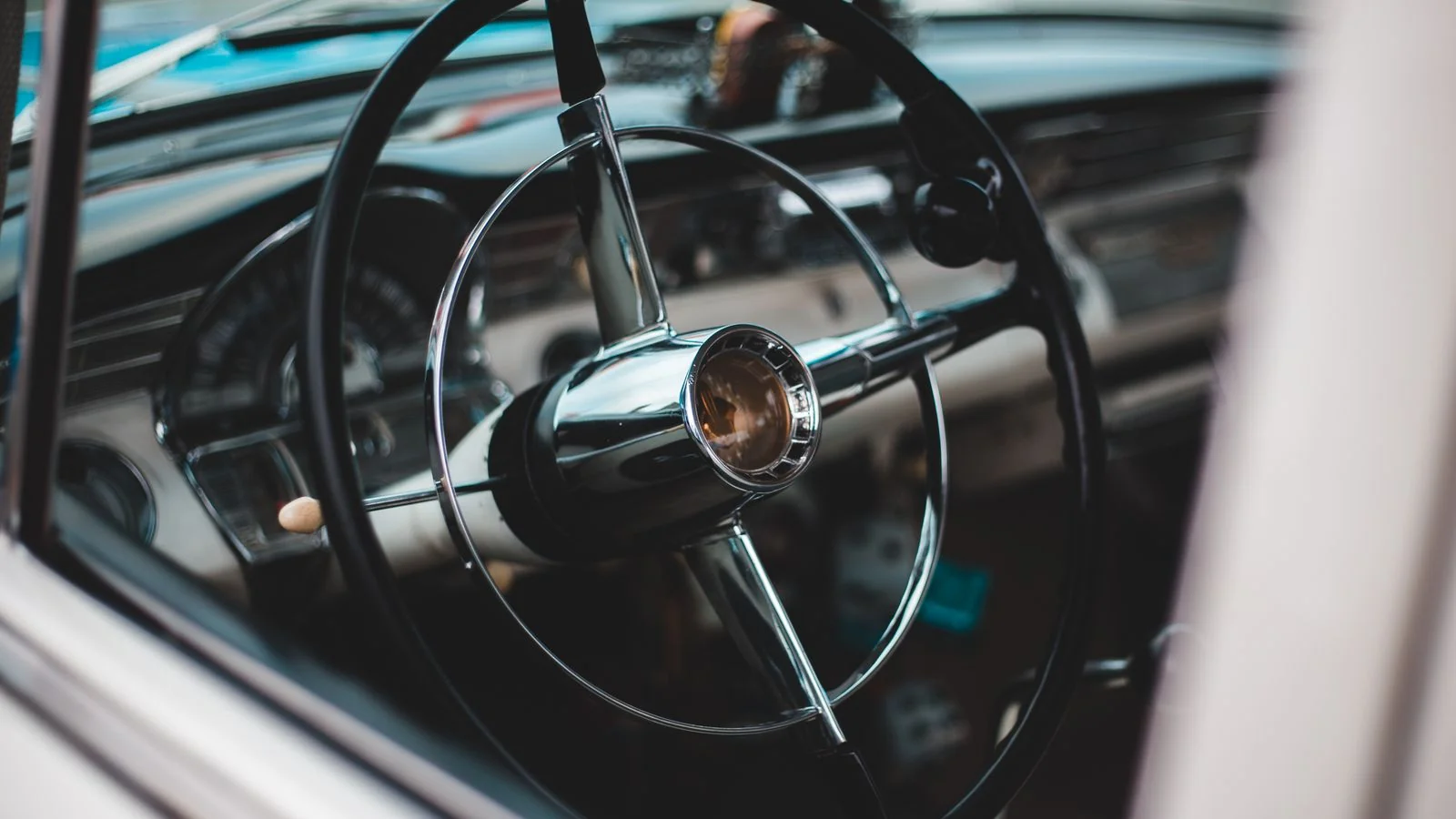Close-up of a vintage car steering wheel and dashboard showing engineering detail