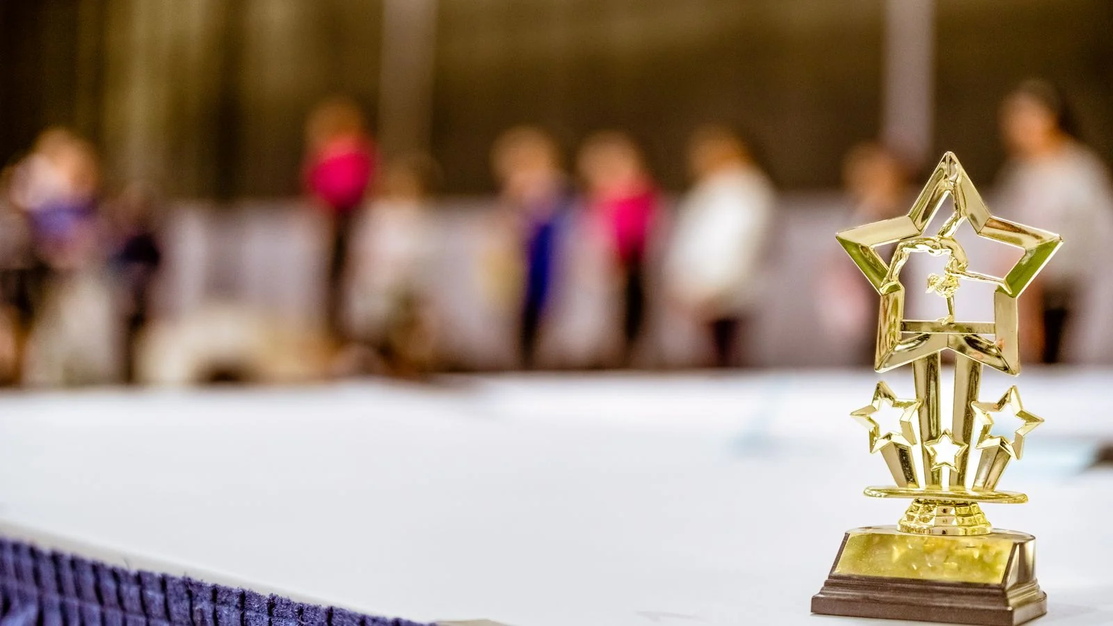 Star-shaped trophy on a table at an awards event with guests in the background