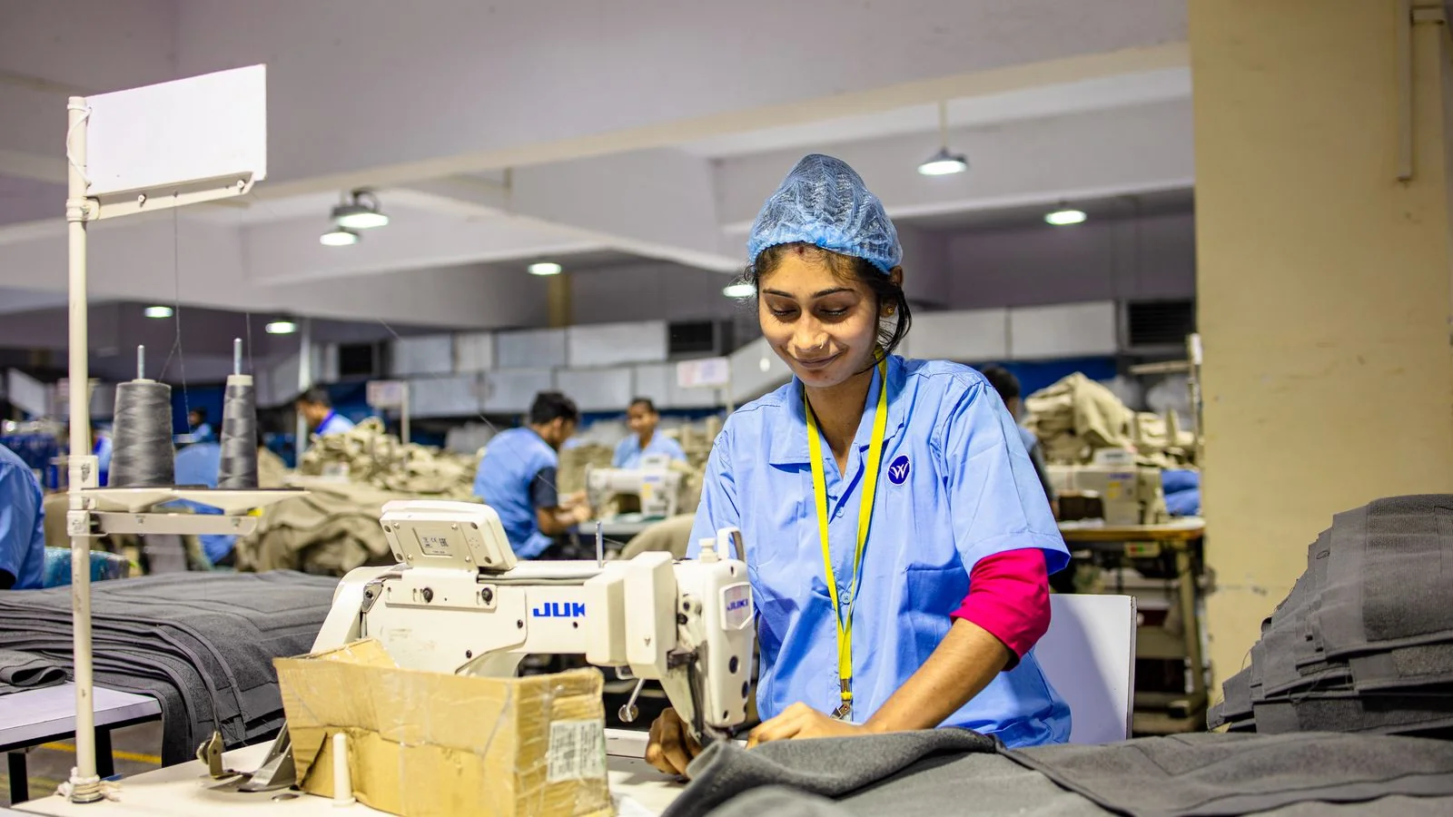 Textile worker sewing fabric on an industrial machine in a garment factory