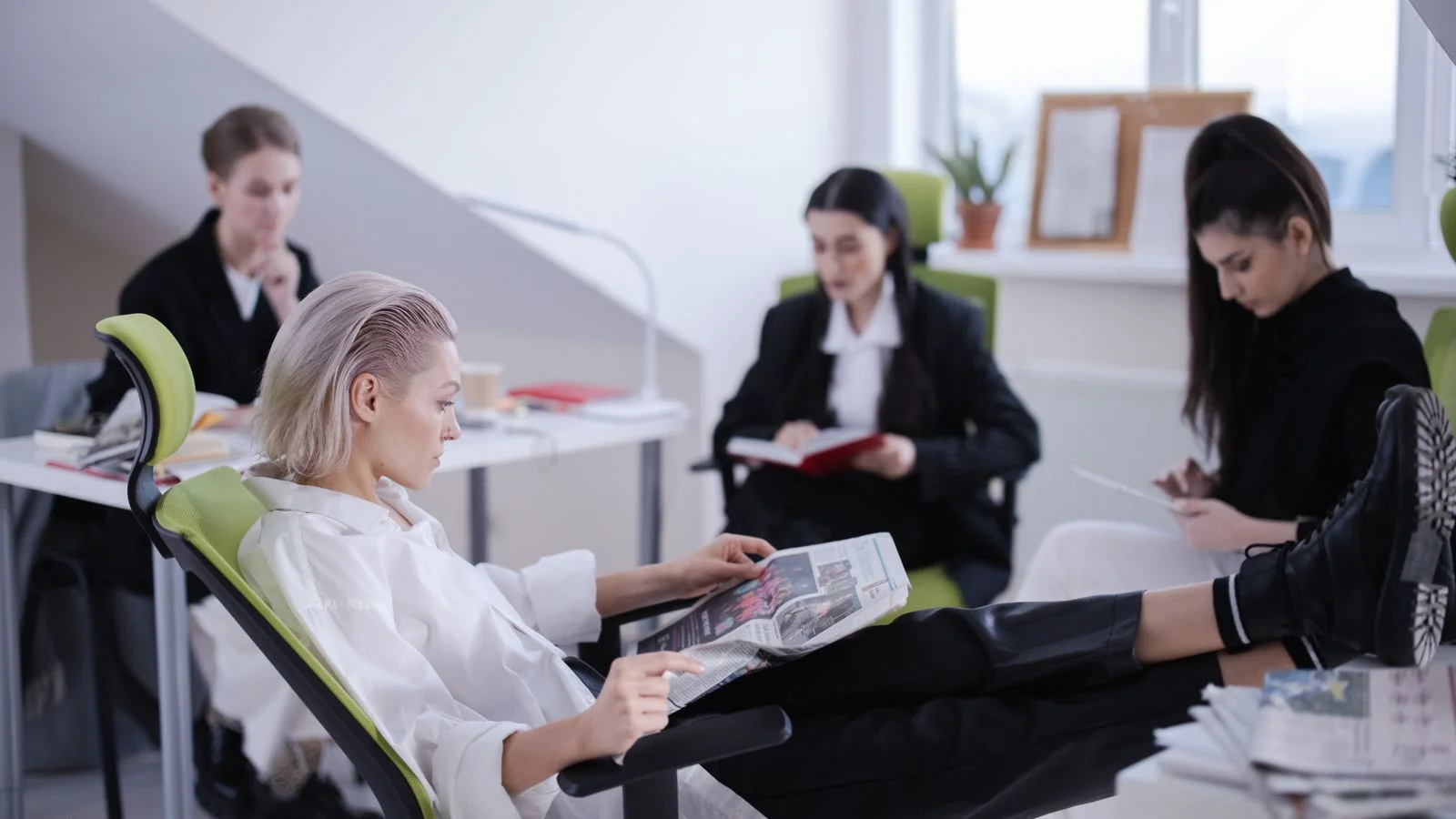Two professionals reading a newspaper in a modern office, the director-level audience Crain's sells to advertisers