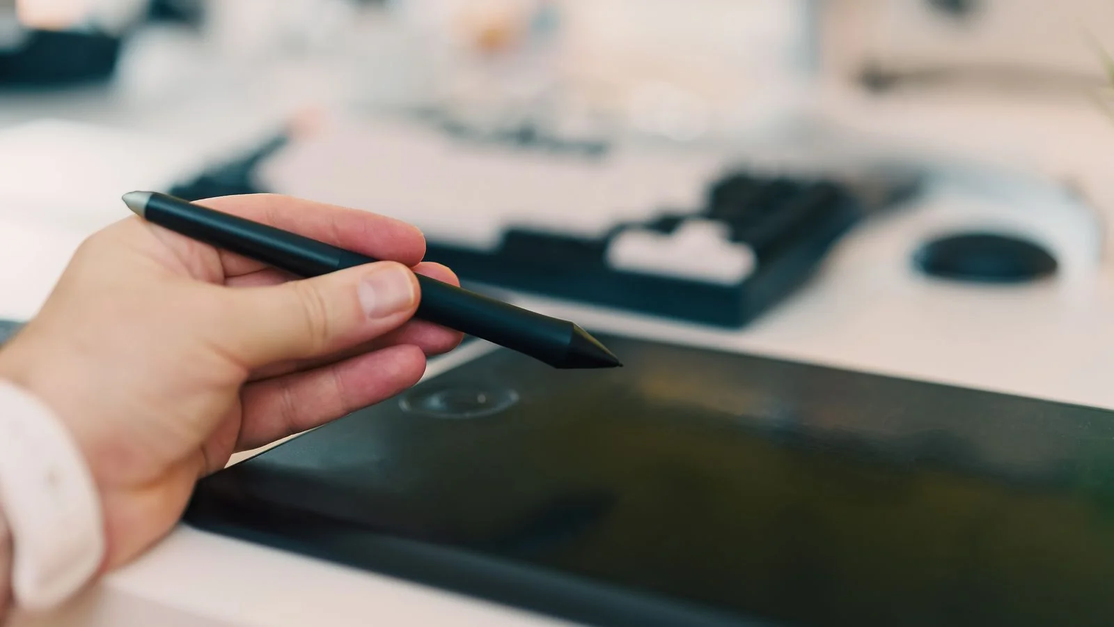 Hand using a stylus on a digital tablet, the specific project design publications want to feature