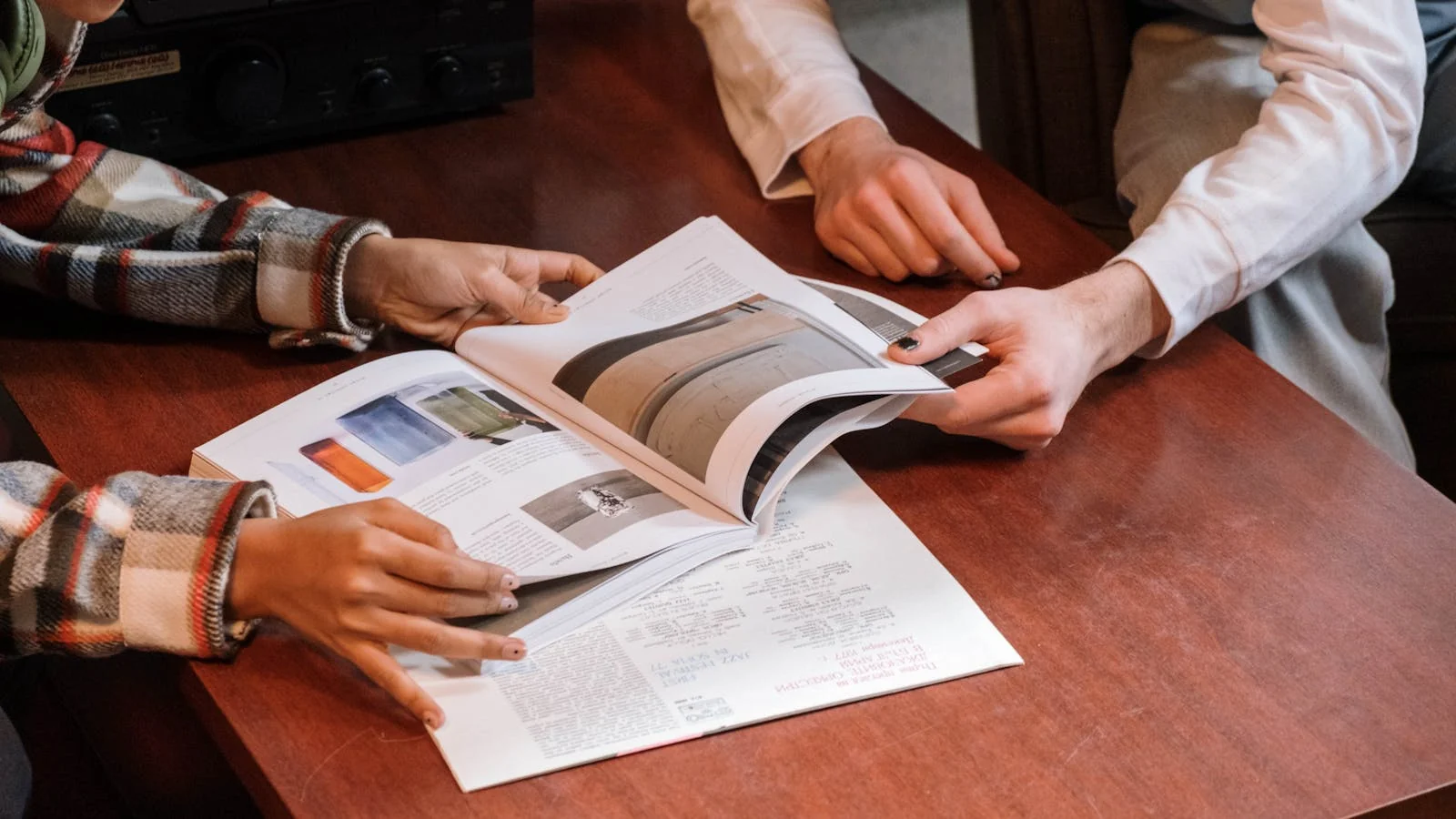 Two people reviewing a magazine together at a table