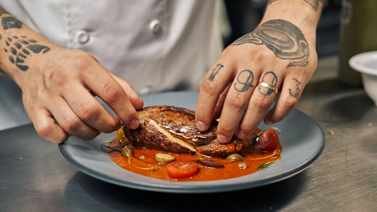 Chef plating a gourmet dish with precision, the signature item a pitch is built around