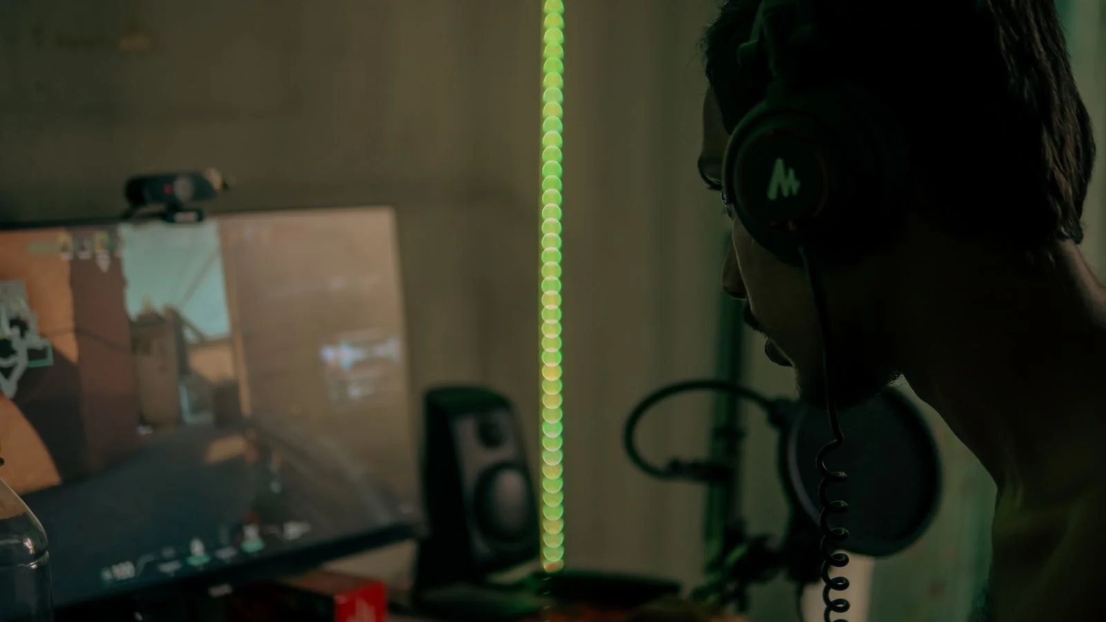 A close-up of a gaming setup with a glowing headset, mouse, and keyboard