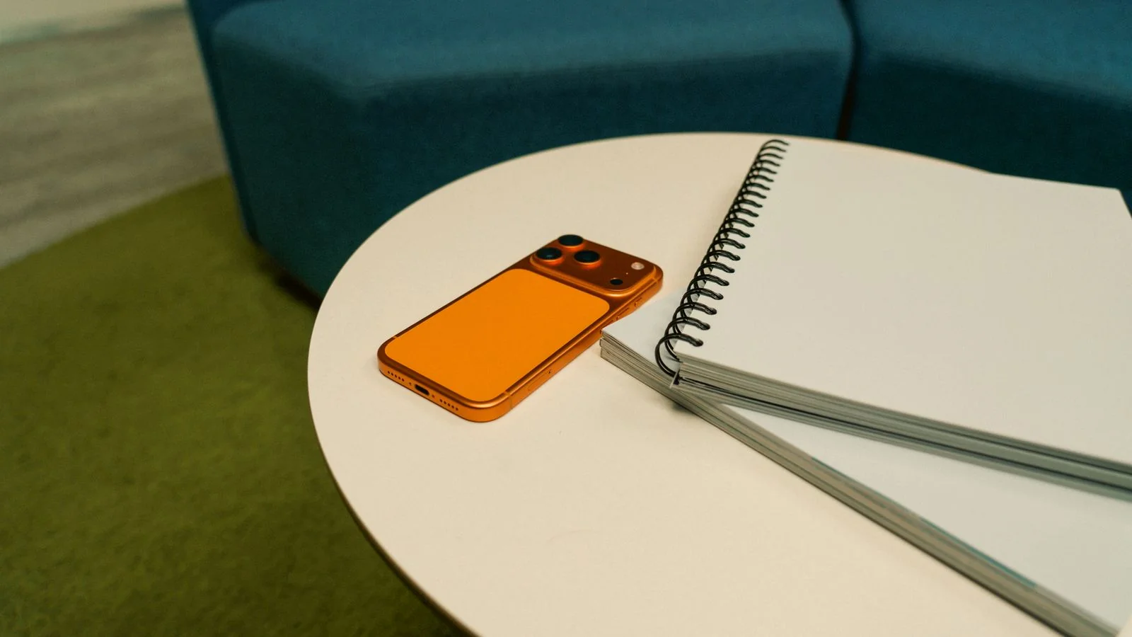 A notepad and phone on a round table, the setup for a quick reporter call on deadline