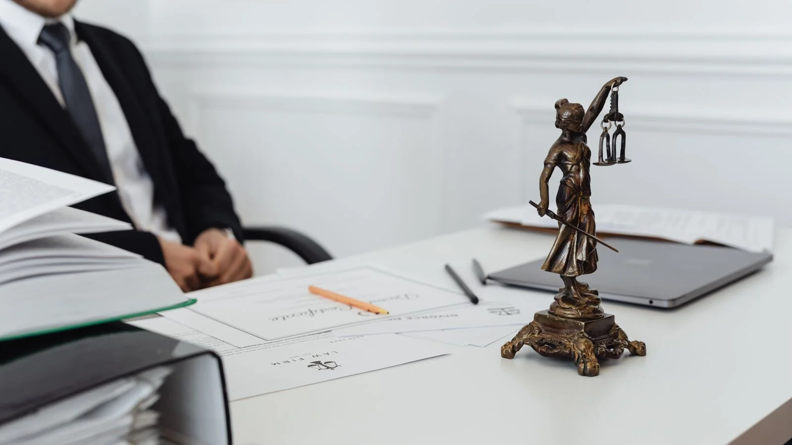 A legal workspace with a Lady Justice figure and a laptop, where authority and credibility meet