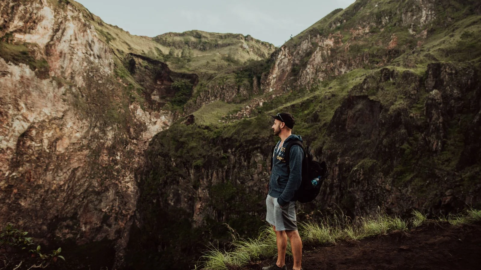 Man hiking a rugged mountain trail with a pack, the capability and grit Men's Journal features