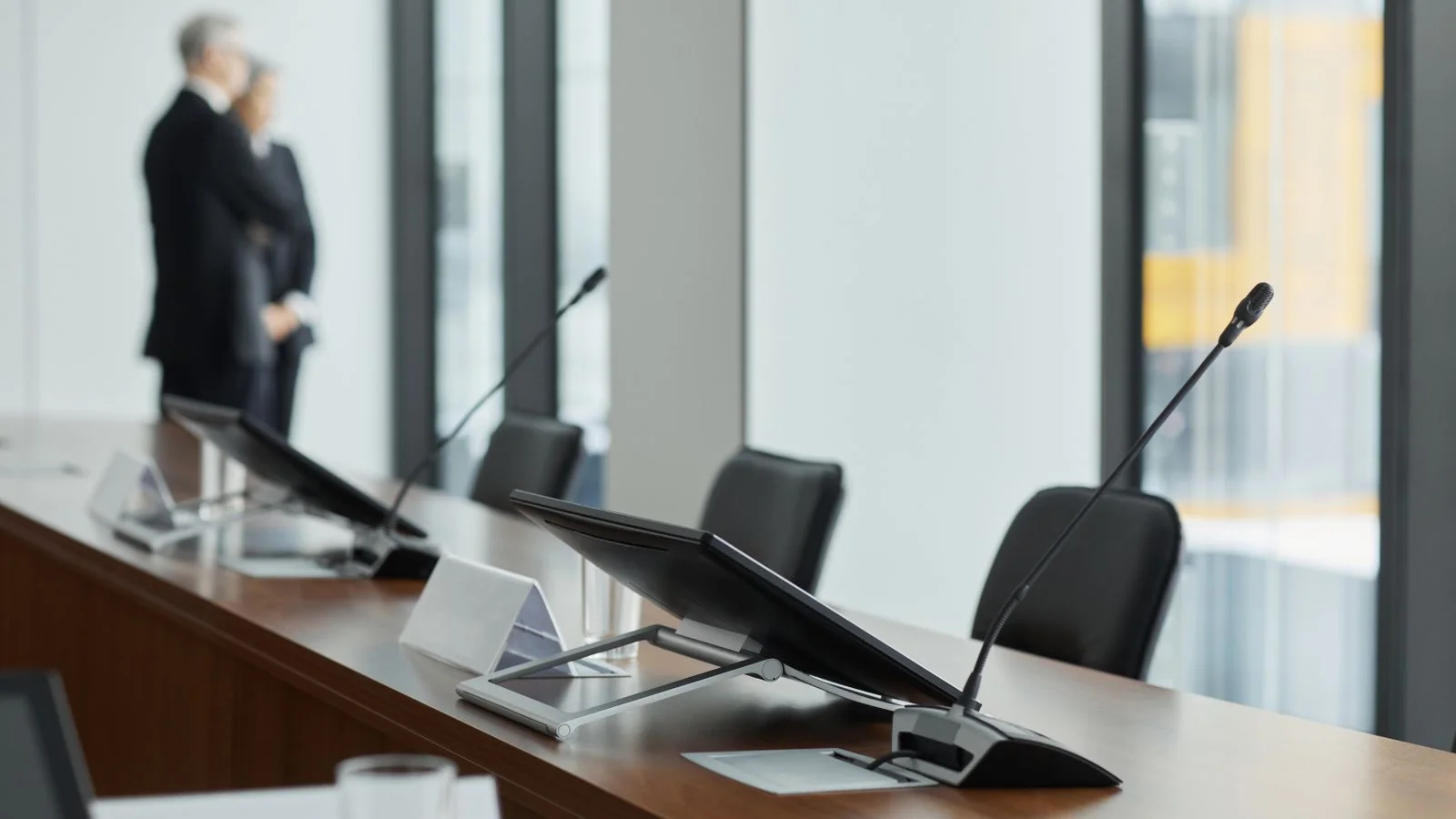 Modern conference room with microphones and screens, the setting for health system leadership meetings