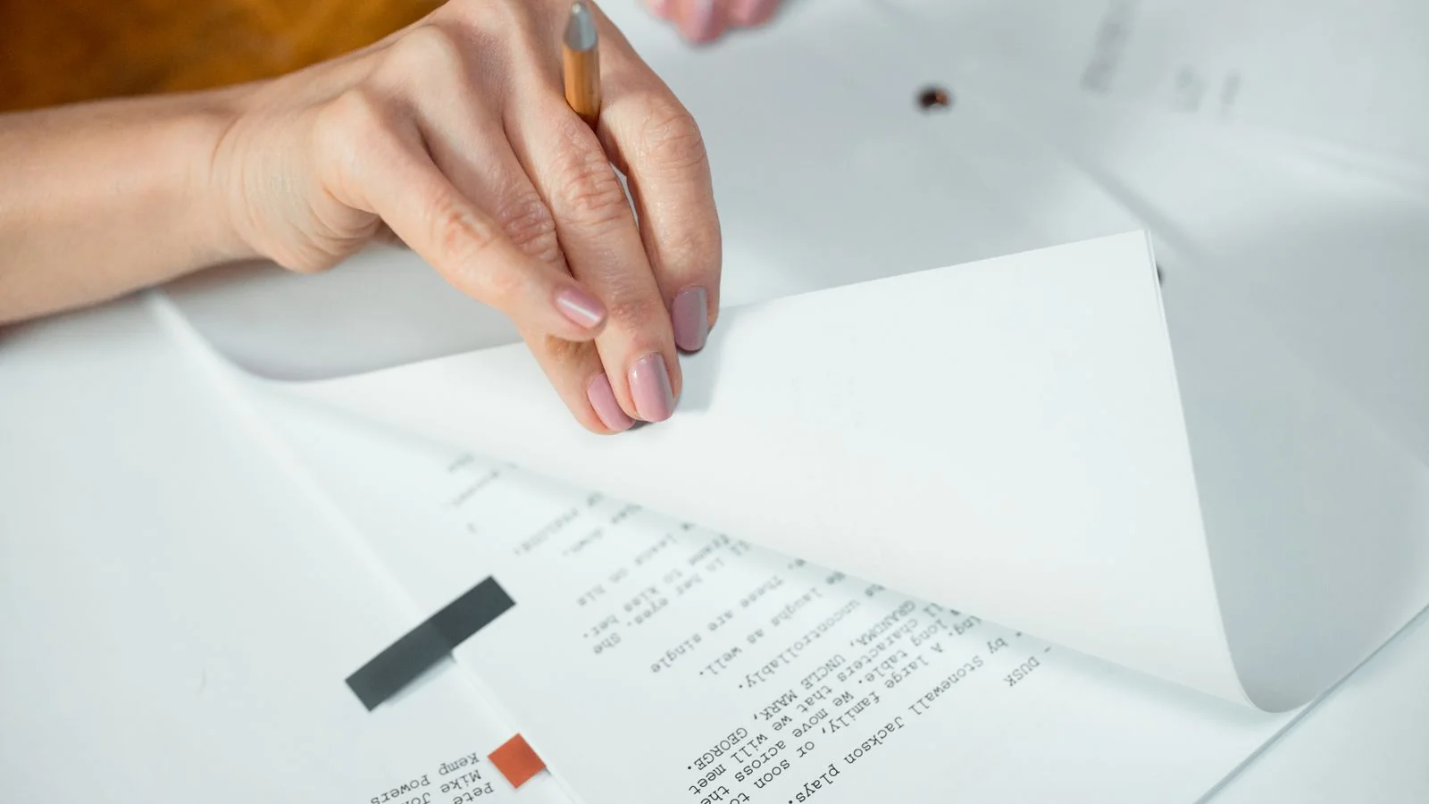 Hands turning pages of a document, the verification work an editor does before quoting you