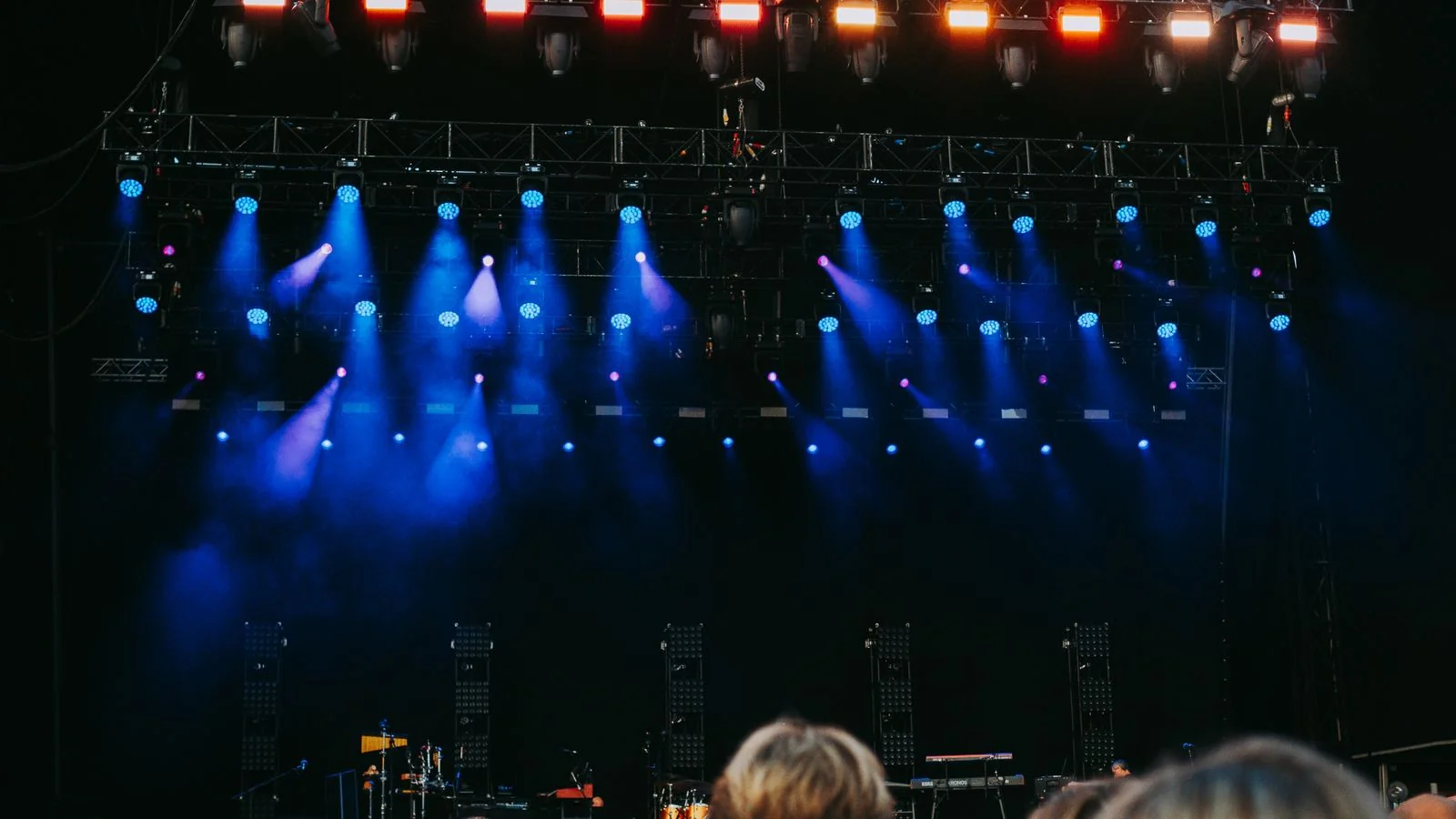 A crowd at a night concert with the stage lit up, the scene music writers are trying to capture for readers