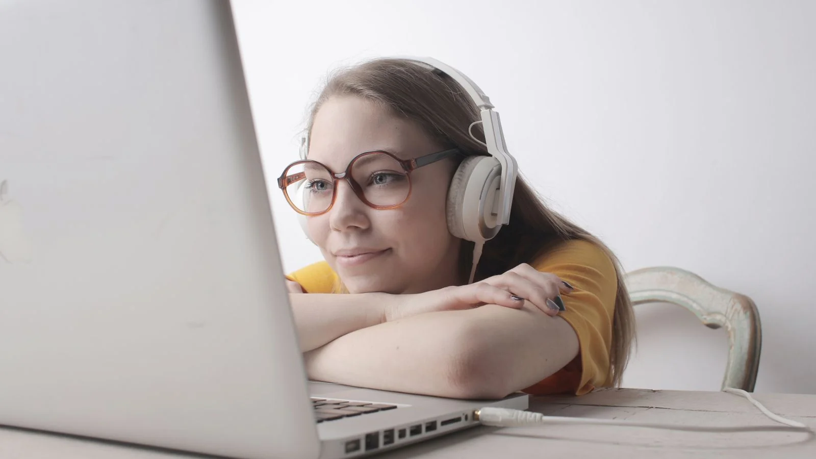 A person wearing headphones and using a laptop, the modern fan asking AI tools for new music recommendations