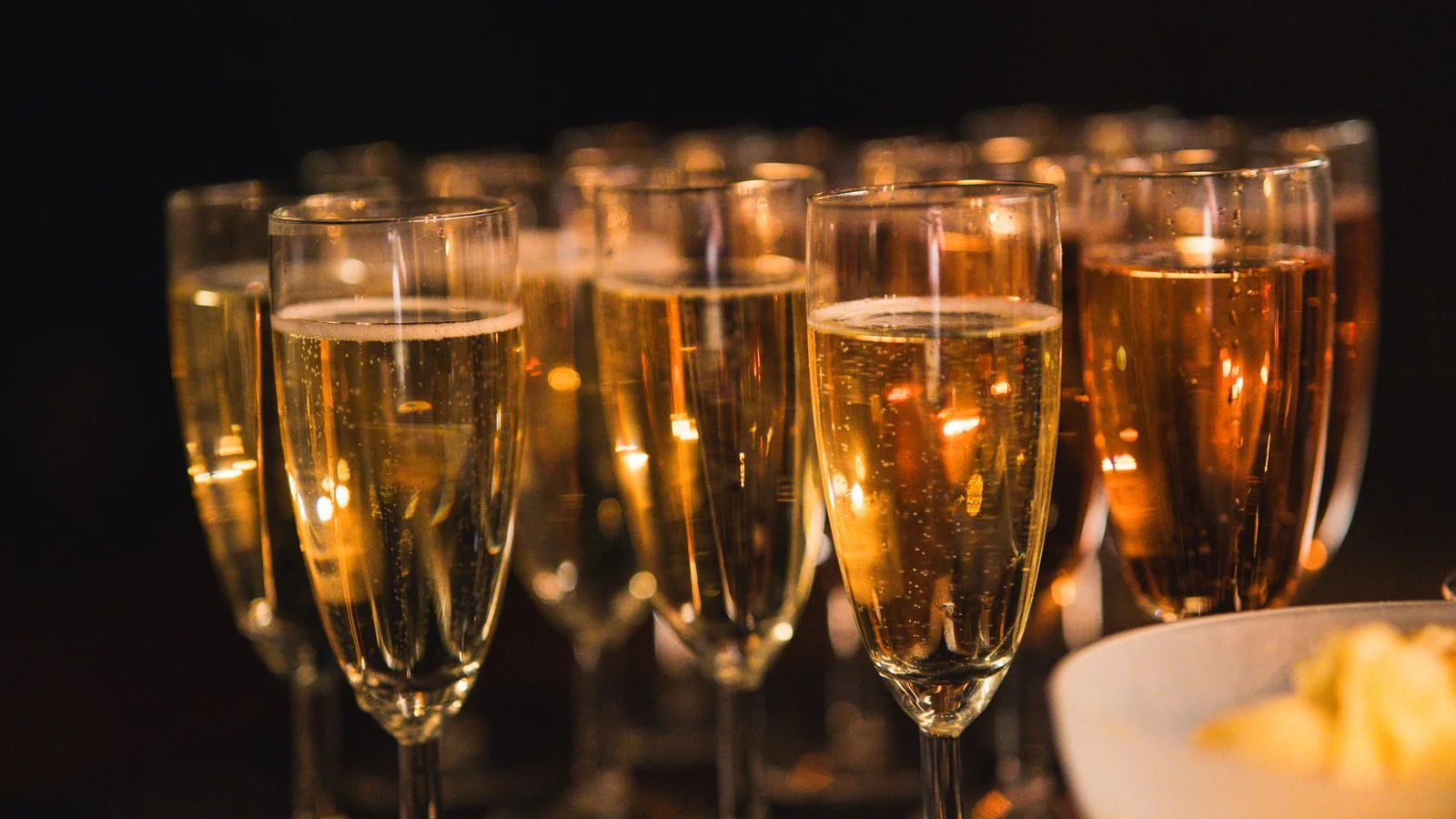 Champagne glasses with rising bubbles lined up for a celebration