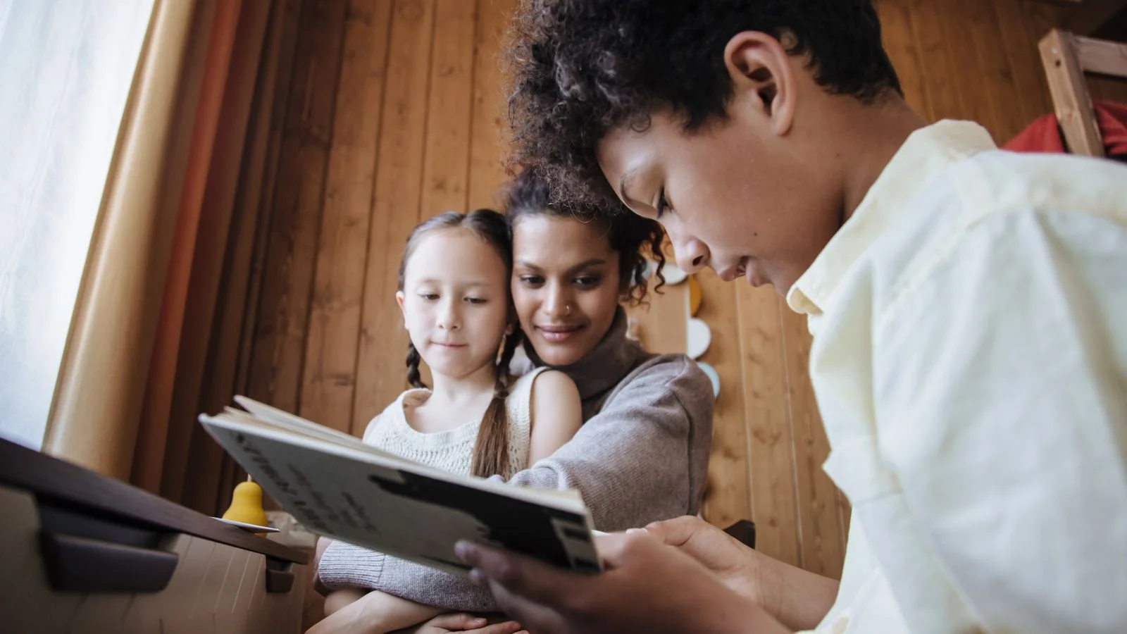 A diverse family reading together in a cozy room, the everyday parenting moments these stories speak to
