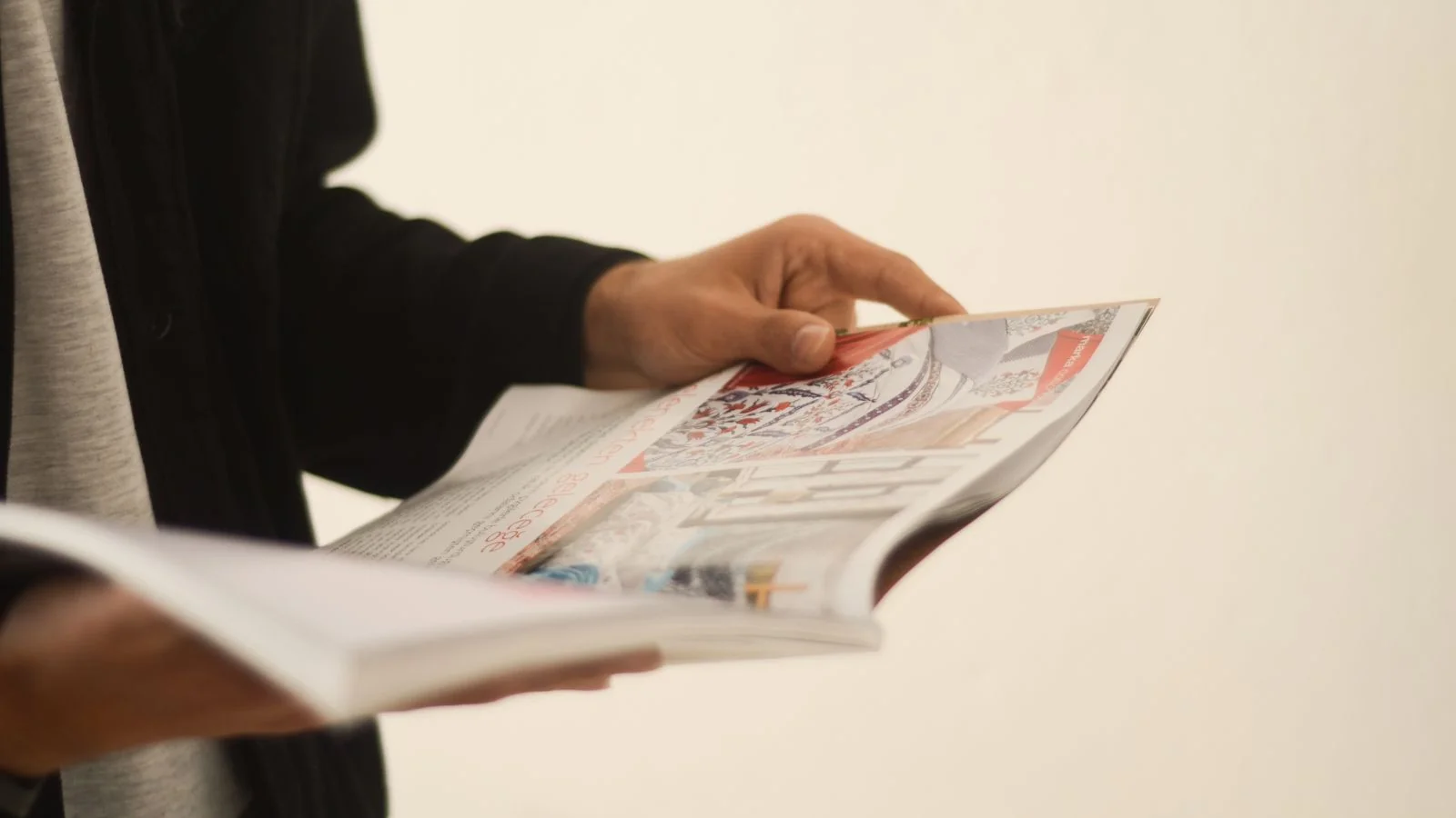 Close-up of hands reading an open magazine, the intimate way a Reader's Digest story gets consumed