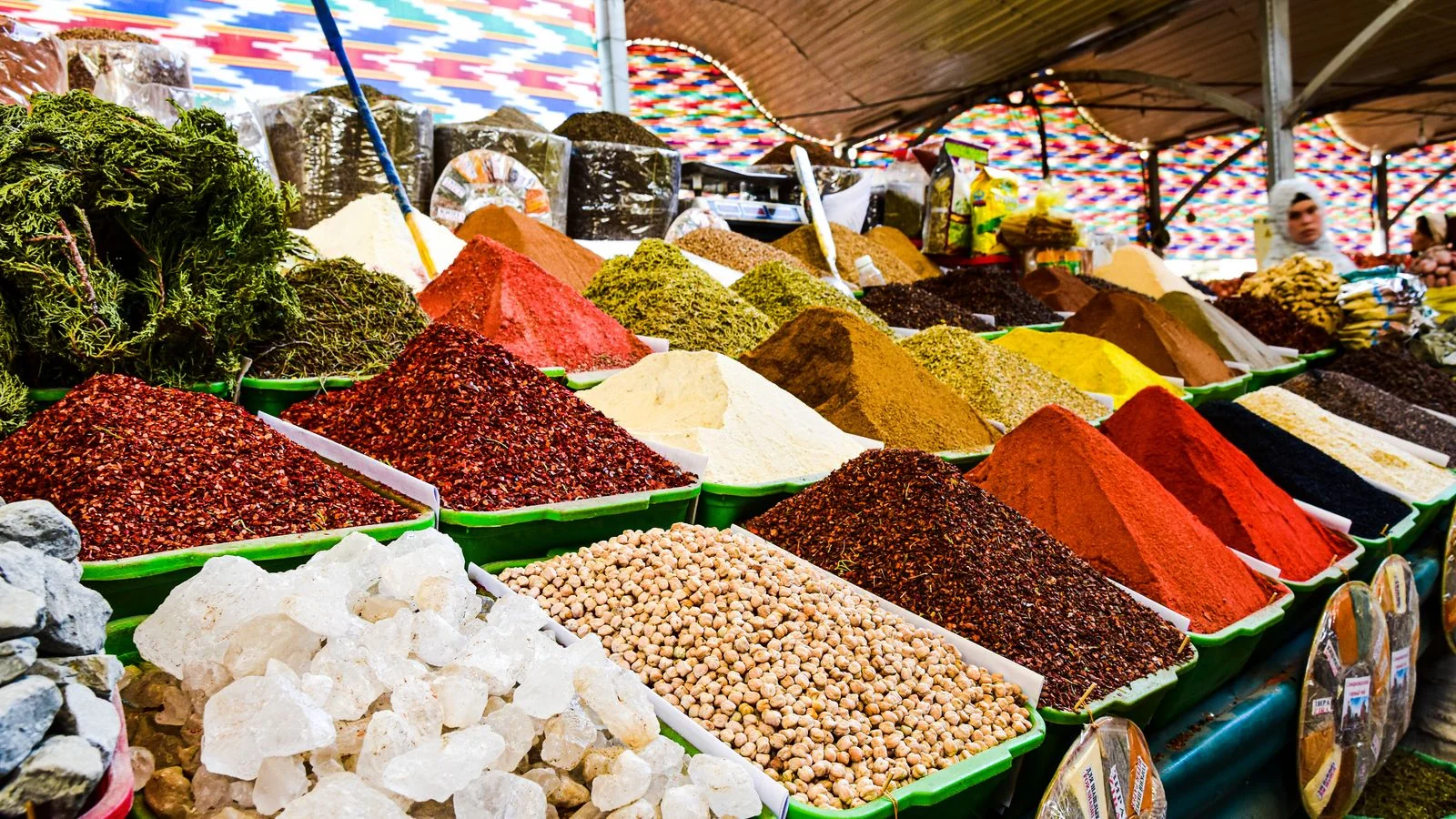 A colorful display of spices piled high at a bazaar market stall