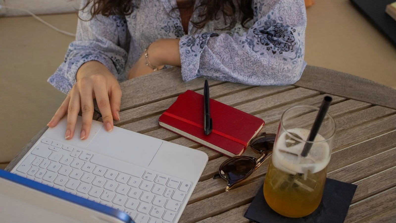 A woman working on a laptop at an outdoor cafe, the everyday life The Cut writes into