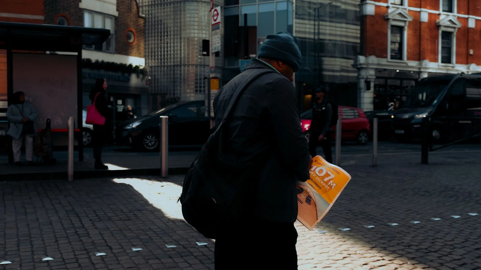 A person on a city street holding a newspaper, the everyday reader MailOnline writes its headlines for