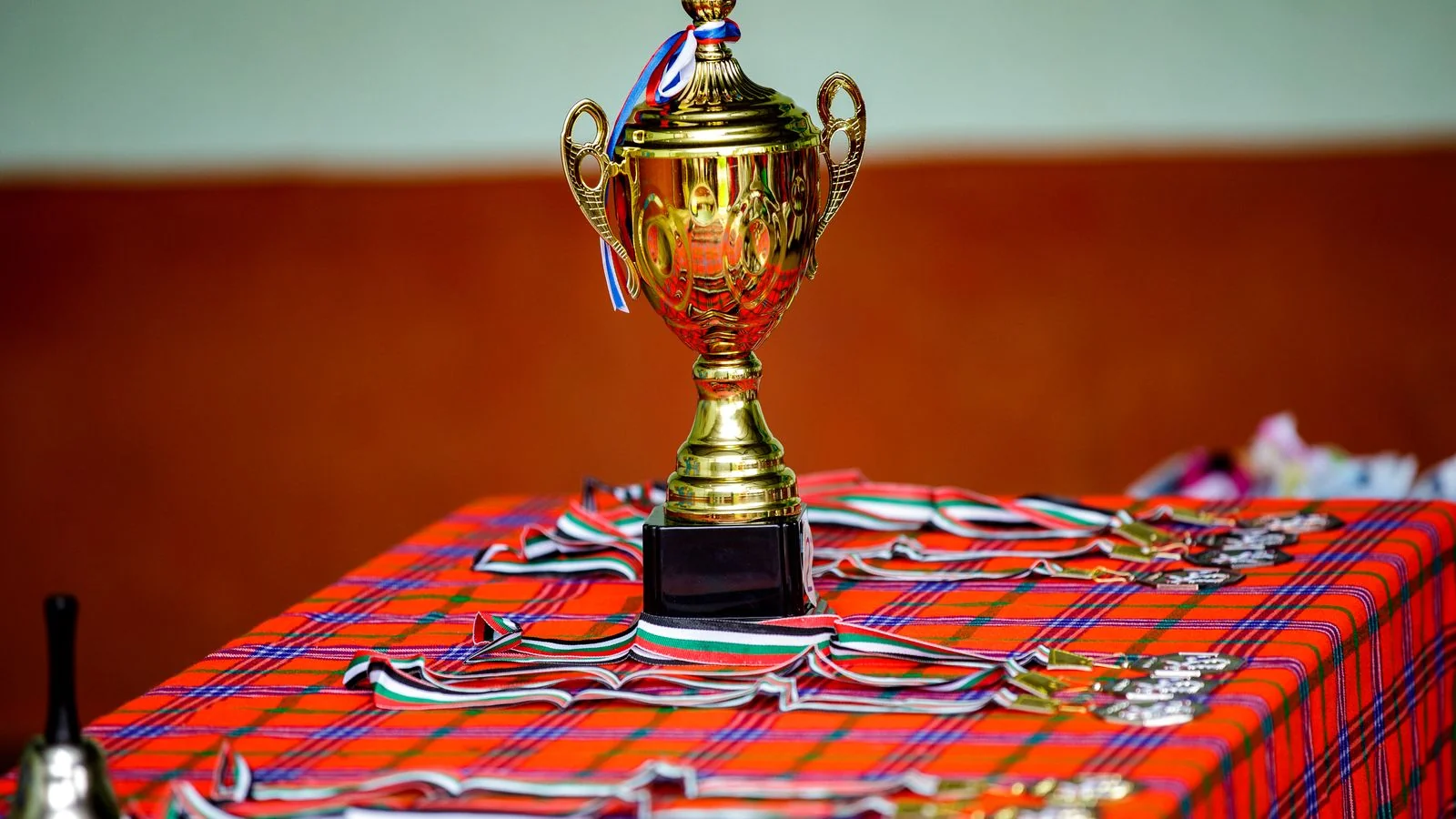 Golden trophy with ribbons and medals on a table, the prize behind The Drum Awards