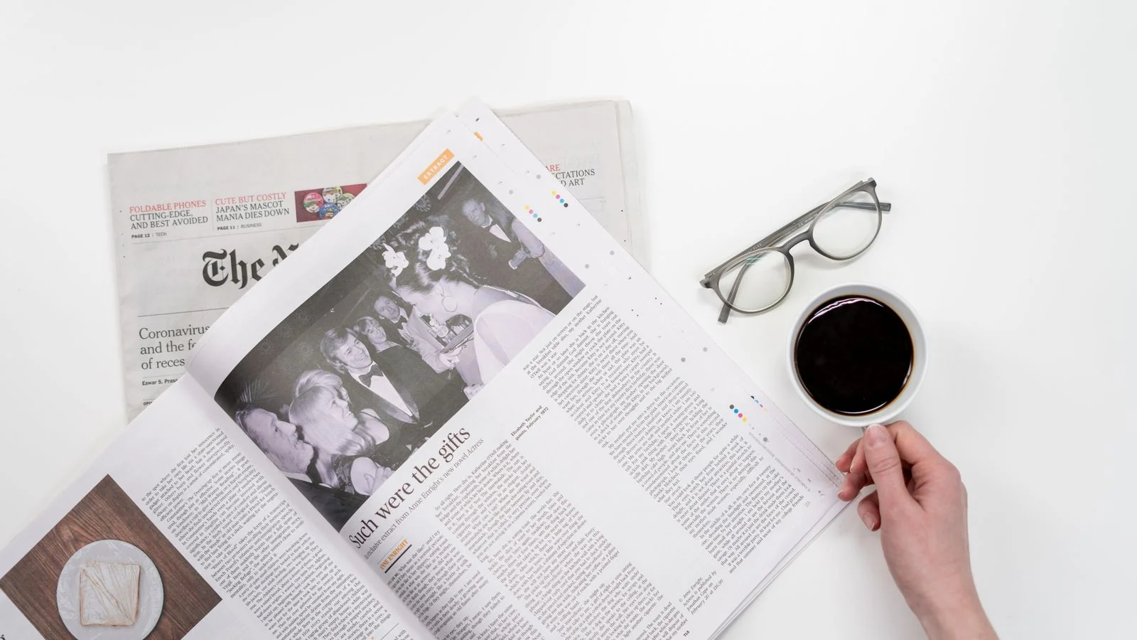 Folded newspaper beside a coffee cup, the reading context a national business desk writes for