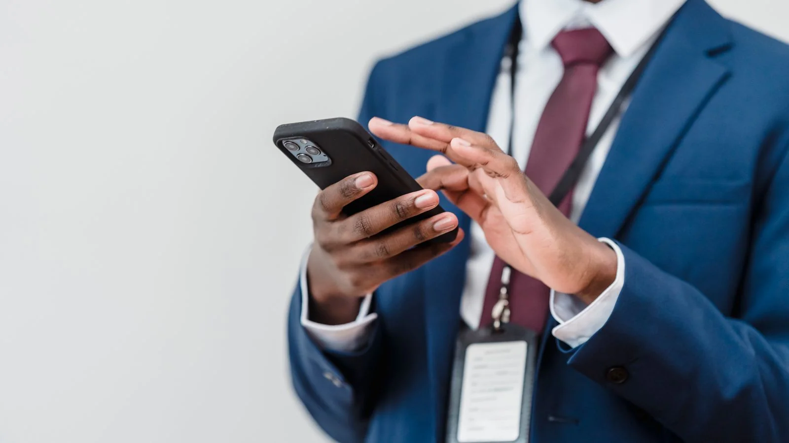 Professional checking his smartphone indoors, scanning the newsletter inbox where a Skimm mention lands