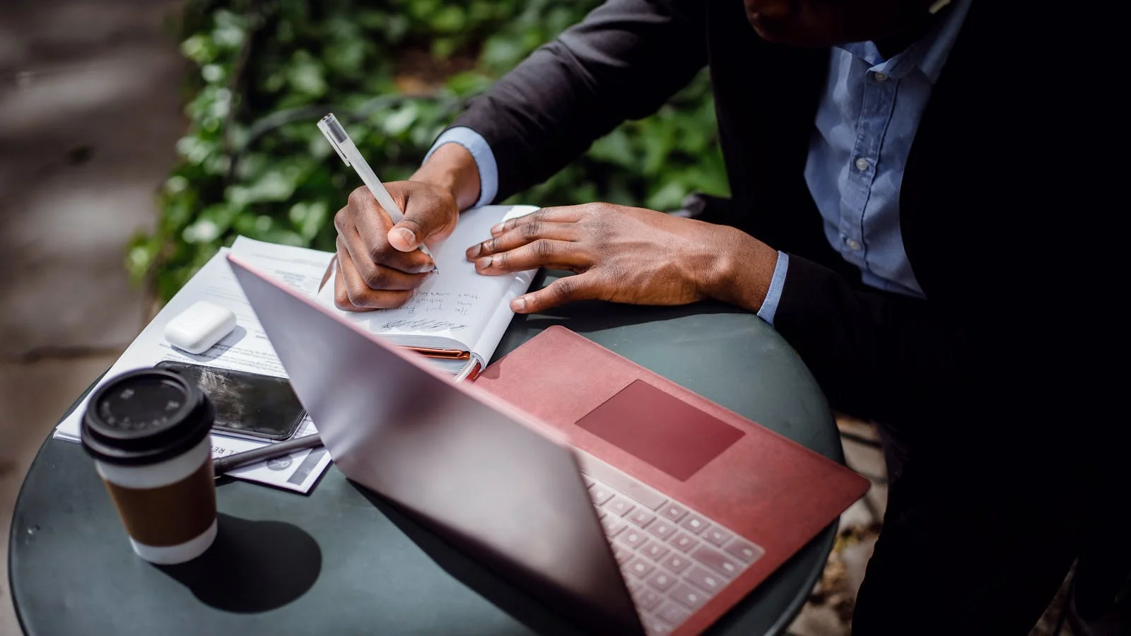A journalist drafting an article on a laptop with a coffee, building a story around an idea.