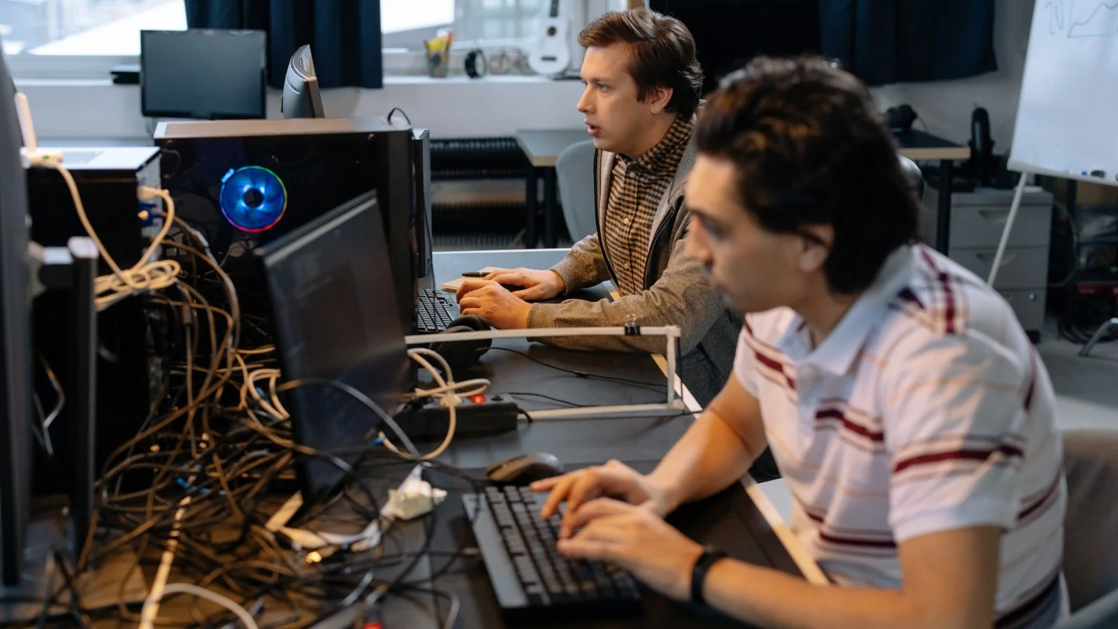 Programmers working side by side at computers in a modern office, the tech workforce Built In serves