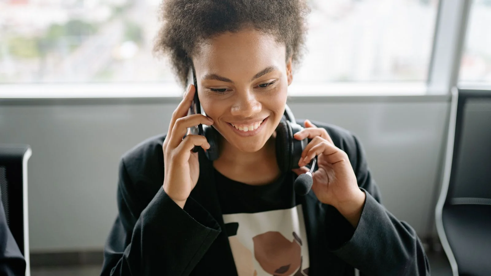 Smiling agent in a headset taking a call, the rep who carries deal news to reporters