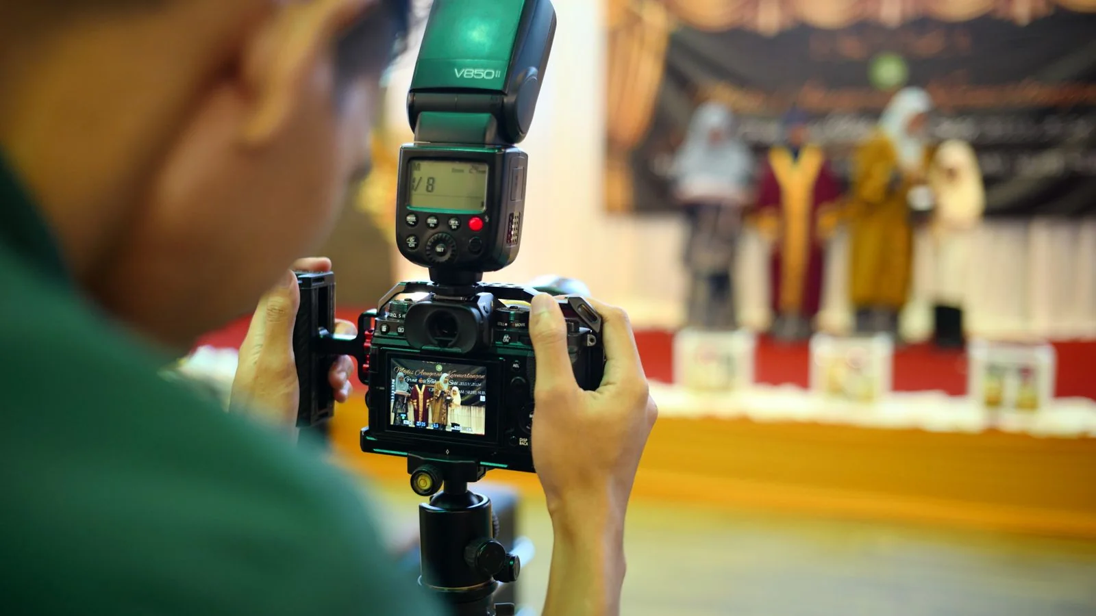 Photographer capturing people on stage at a live event, the kind of moment entertainment desks need fast