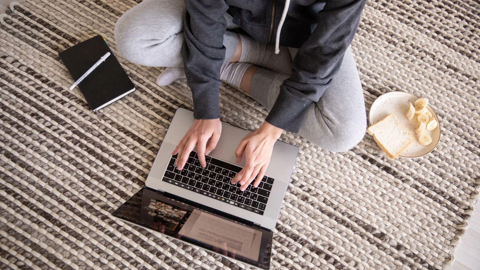 Woman working on a laptop at home with a notebook, replying to a reporter query