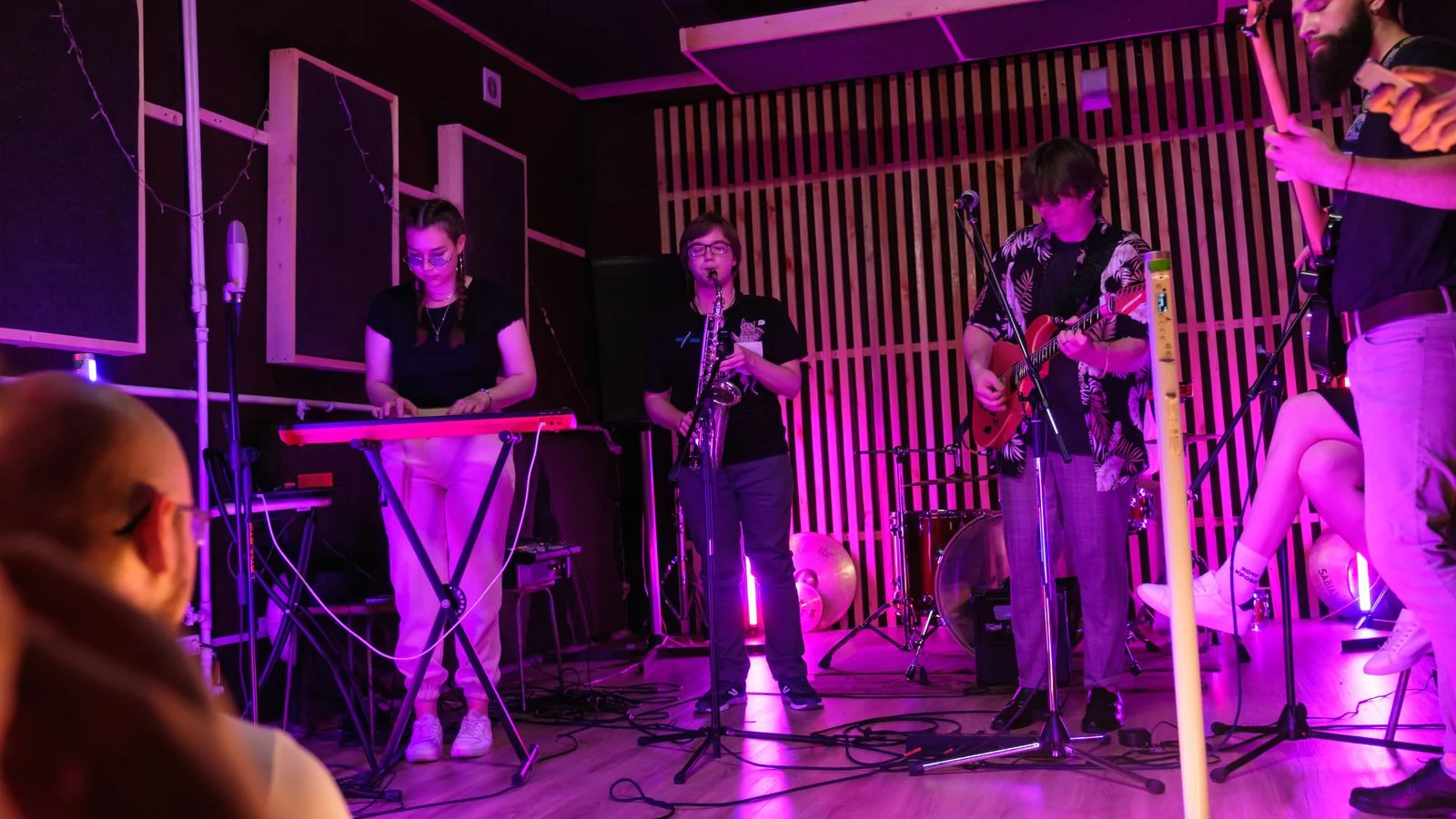 Live band performing on a small indoor stage to a local crowd