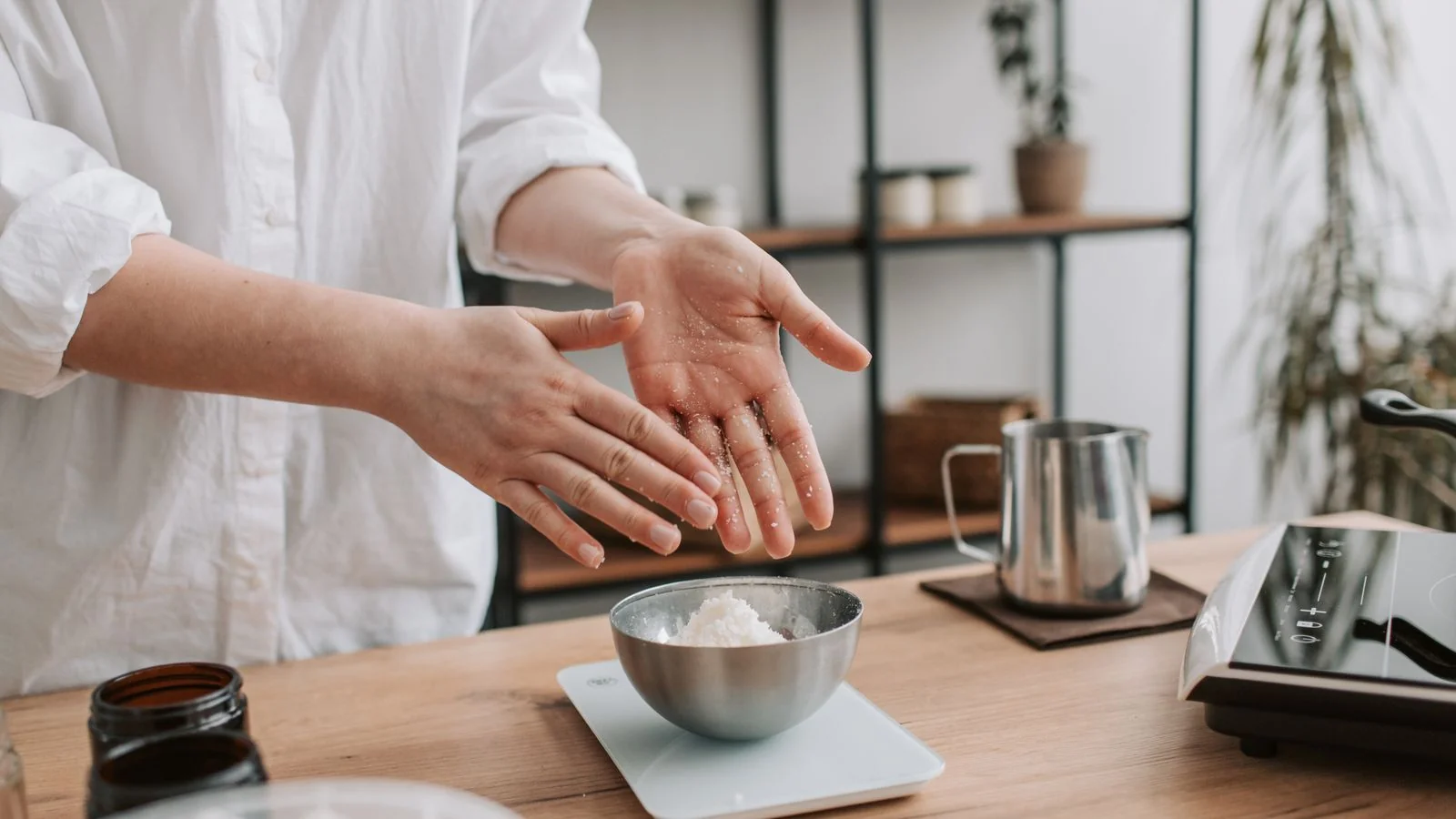 Hands preparing chopped ingredients on a counter in a modern kitchen, the prep stage of Serious Eats recipe testing