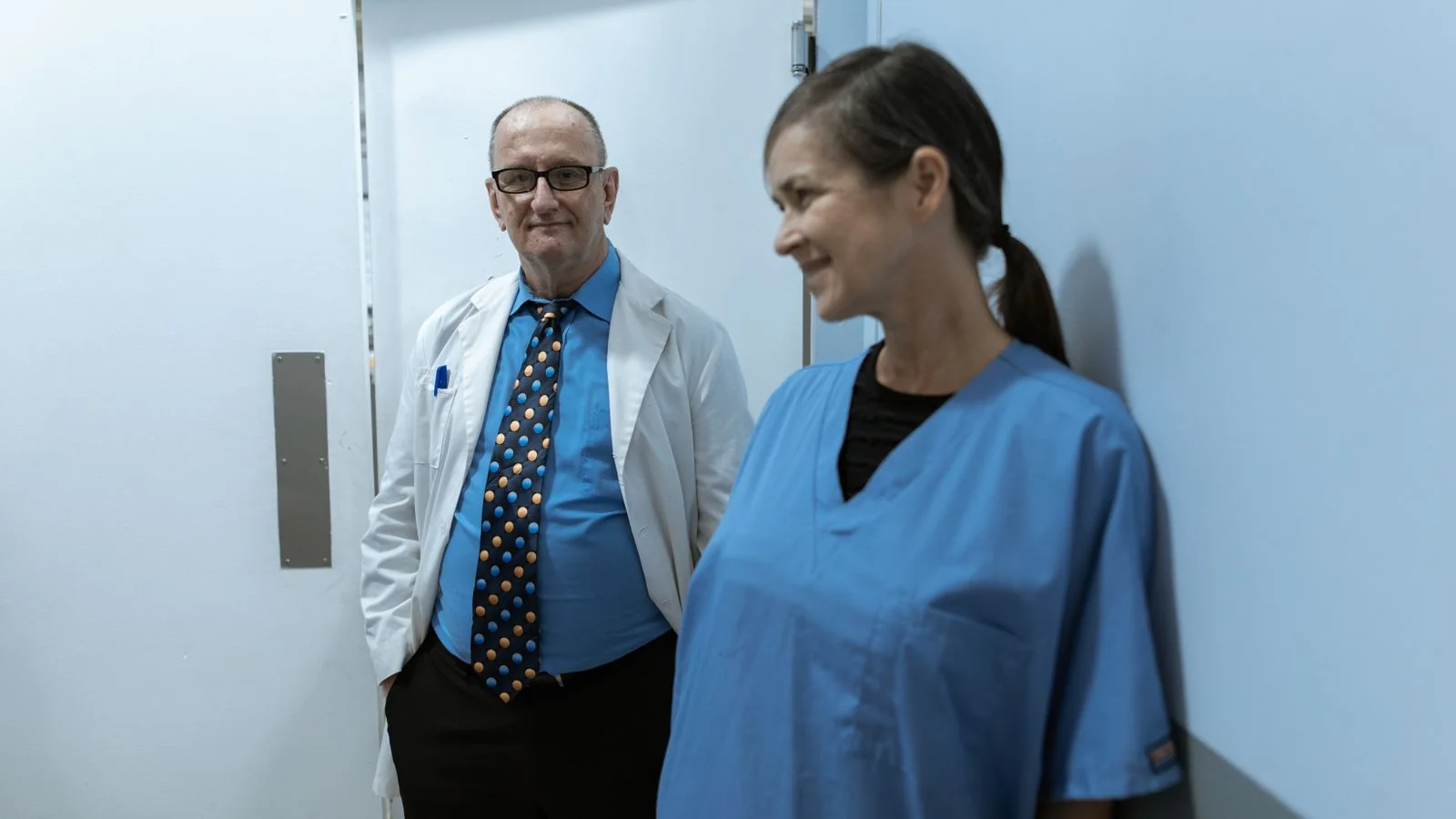 Doctors and nurses talking in a hospital hallway, a team of clinicians at work
