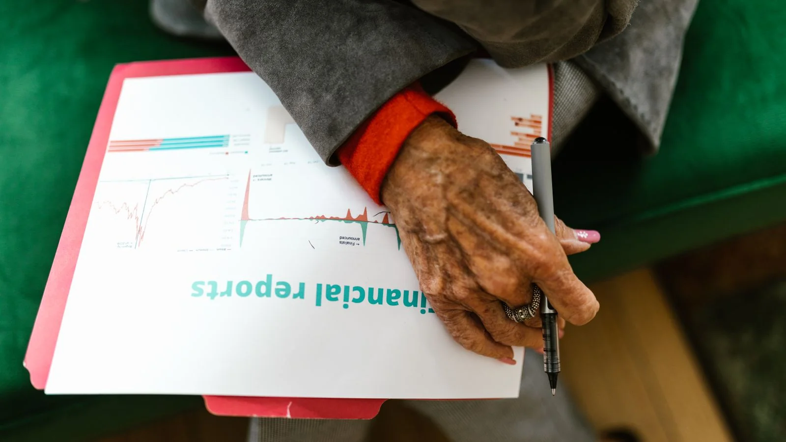 A woman reading a printed financial report with a pen, the retail investor this reaches