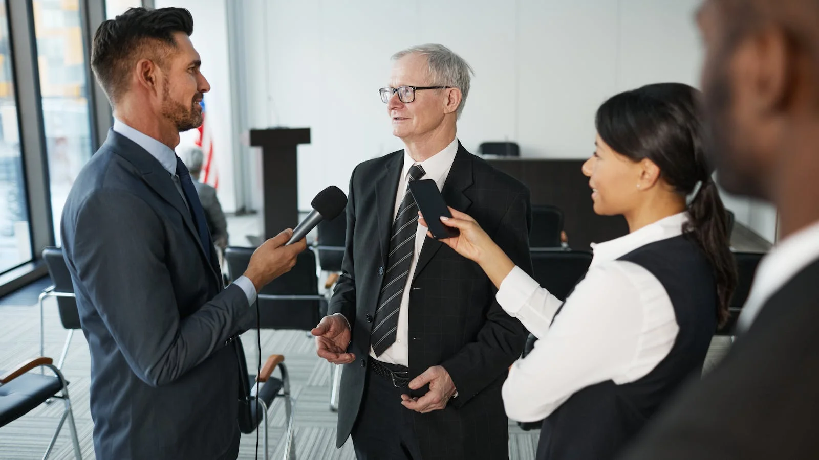 A senior executive answering questions from journalists in a conference room, the production-ready setup a CNBC booker is implicitly evaluating in every pitch.
