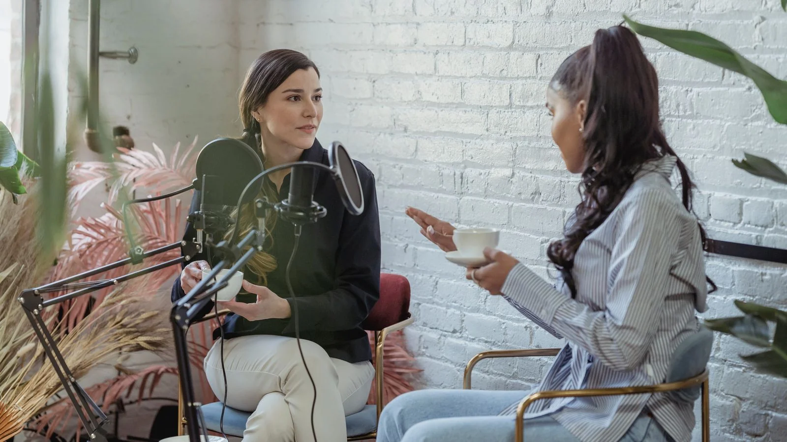 Interview in progress with a host listening to a guest speaking into a studio microphone