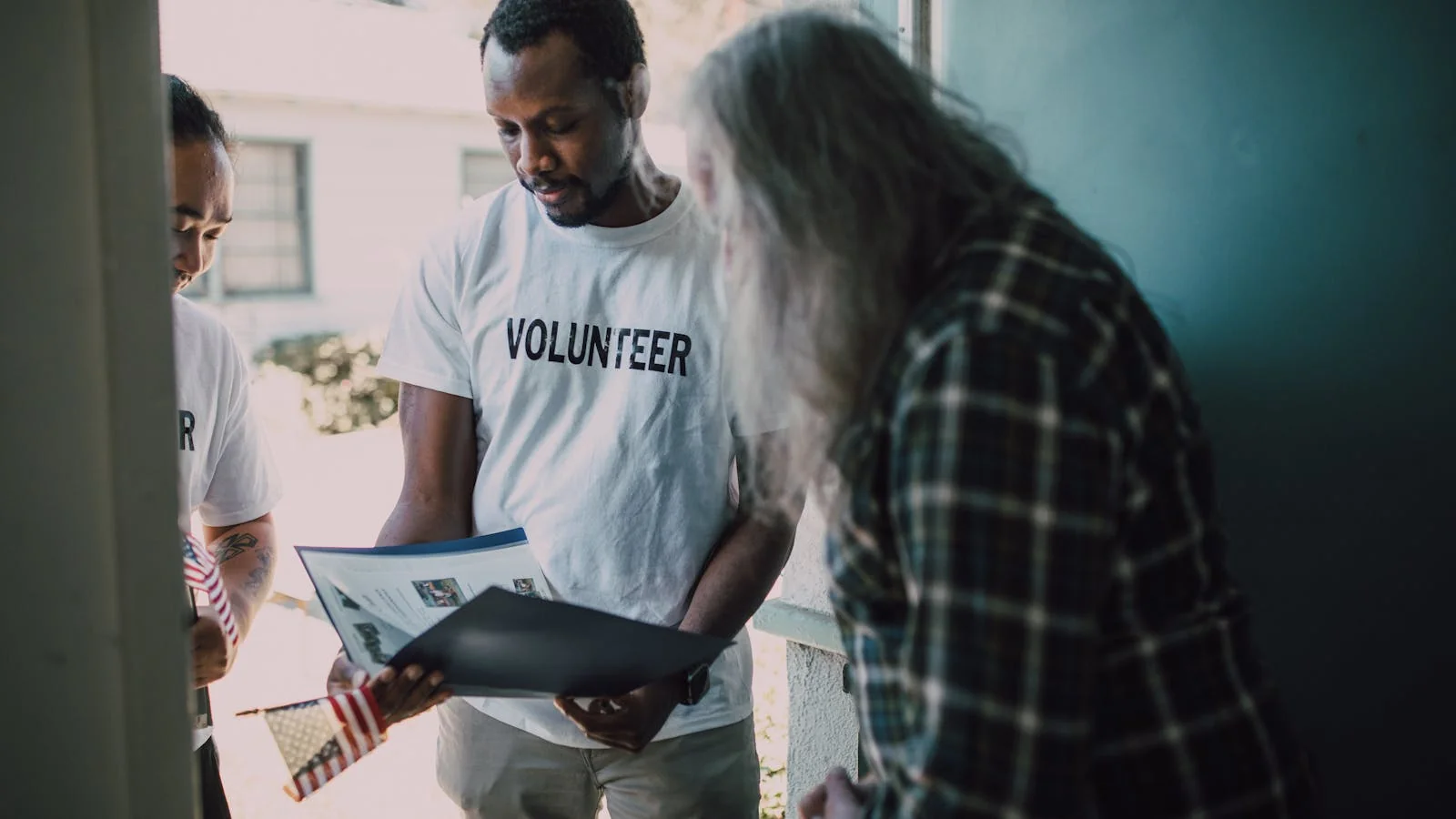Volunteers in matching white shirts visiting a home to provide community outreach support