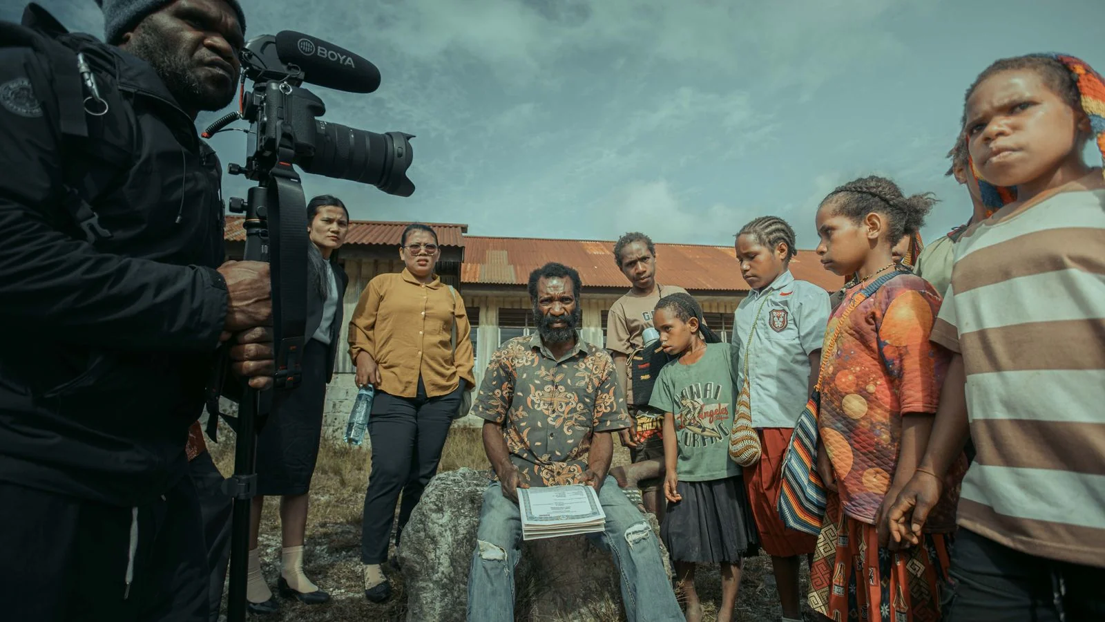 A filmmaker recording a group outdoors, the kind of access that makes an expert useful to a news desk
