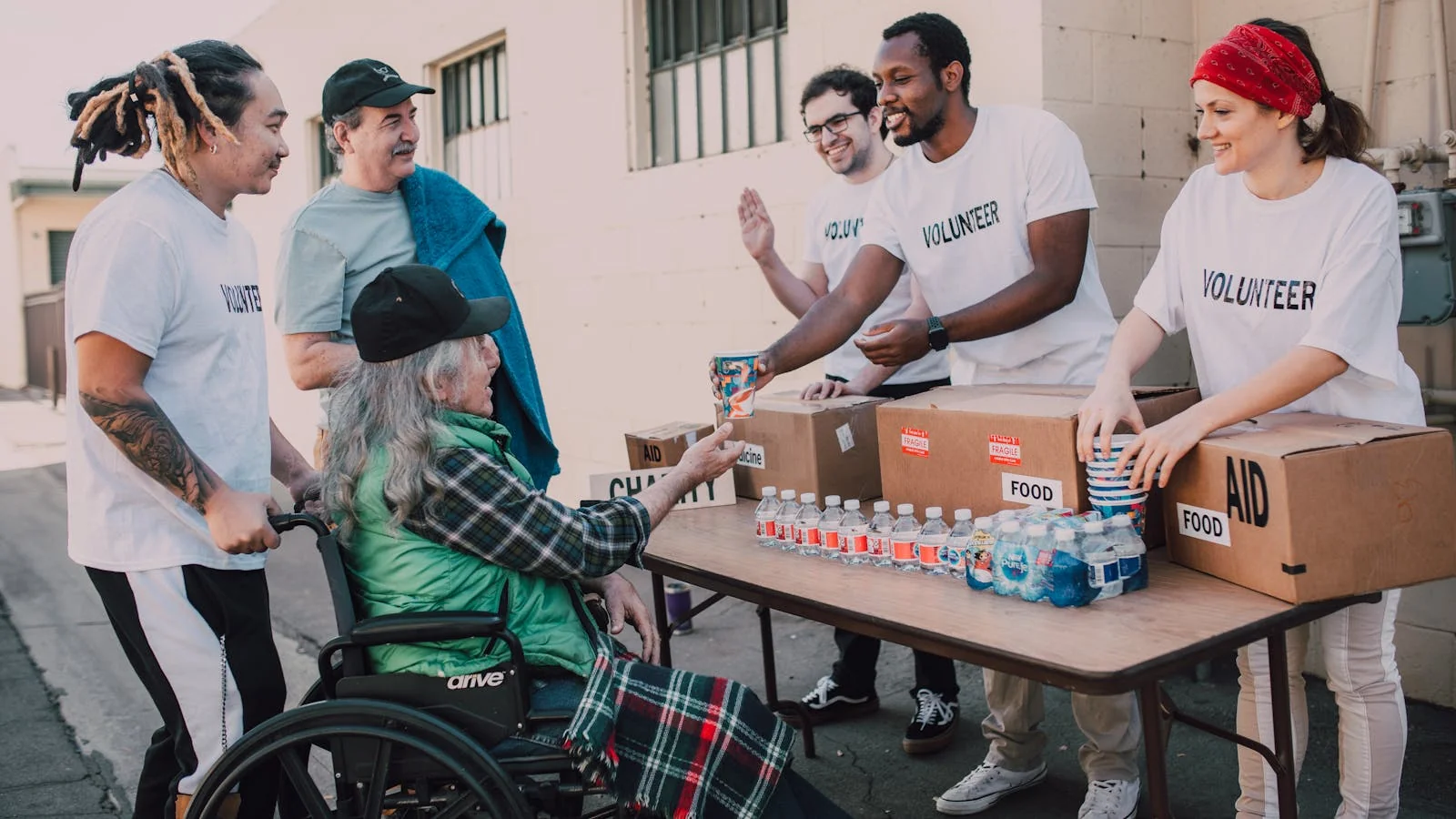 Volunteers handing out water and supplies at an outdoor community event.