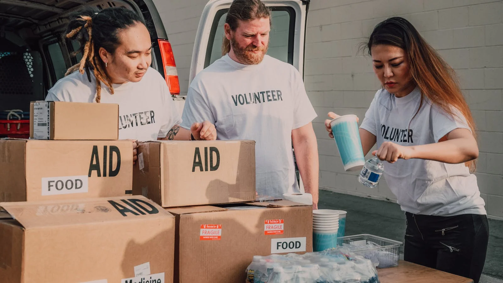 Volunteers sorting boxes of donated food and supplies for a charity distribution drive