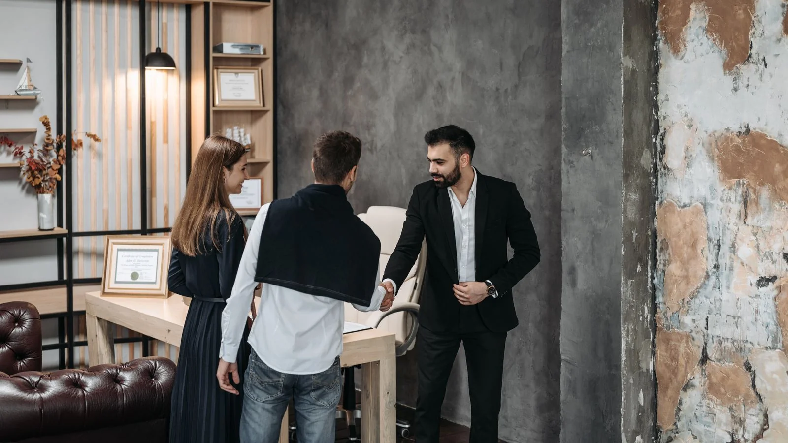 Business professionals in a modern office discussing terms and shaking hands