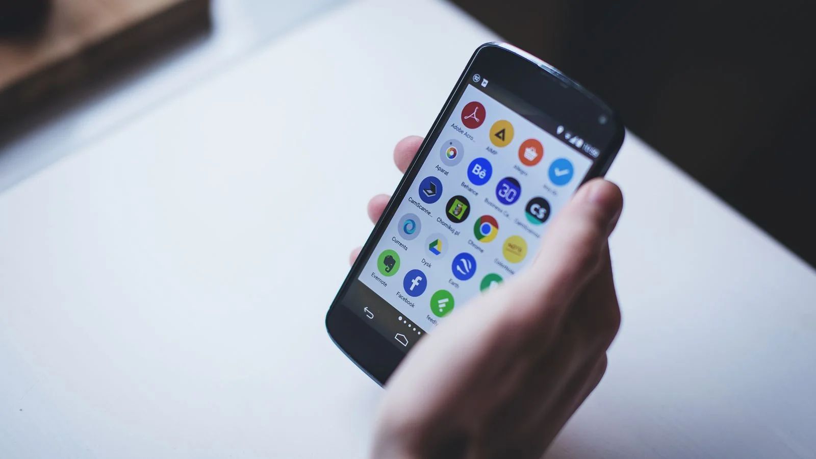 Person holding a smartphone displaying app icons, the everyday problem a mobile app press pitch should open on