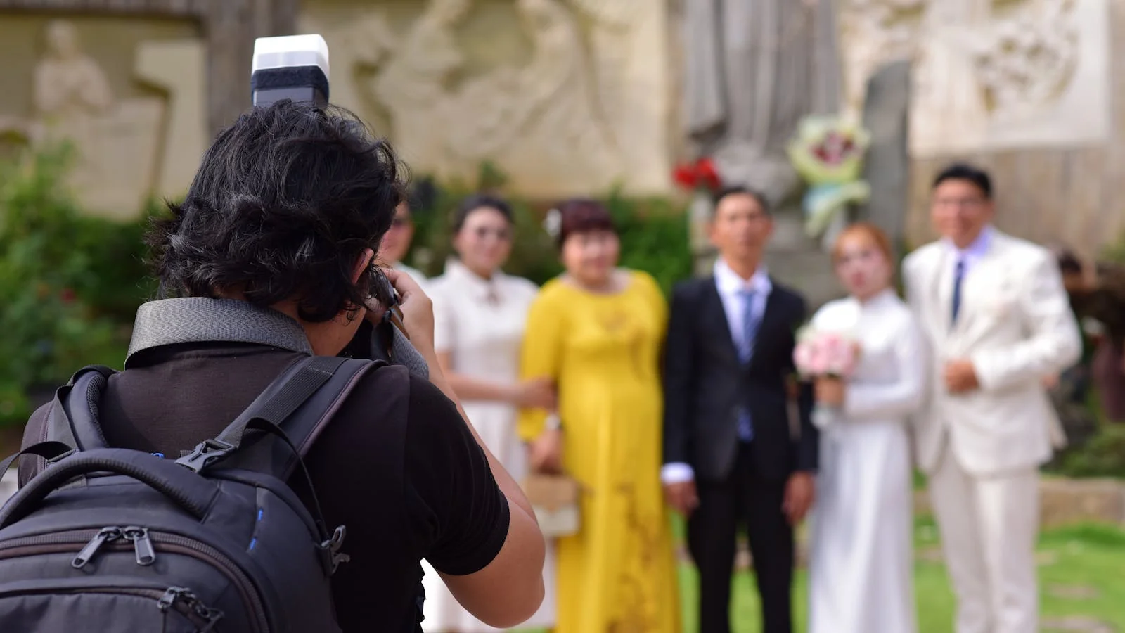 Two people getting married in an outdoor ceremony as a photographer documents the moment, the local-feature kind of wedding most regional press wants to cover.