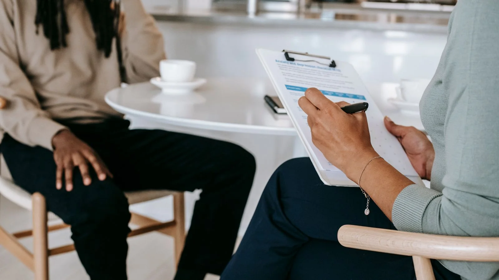 A person taking notes on a clipboard during an interview.