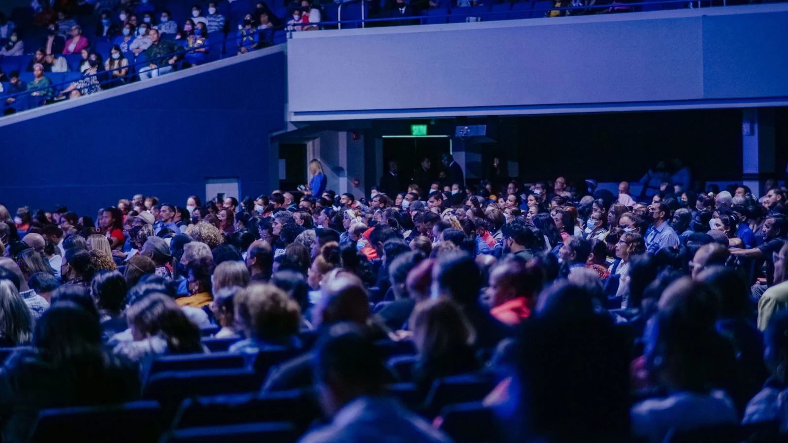 A crowded conference hall with an attentive audience, the kind of gathering that becomes a story when someone describes what happened in it