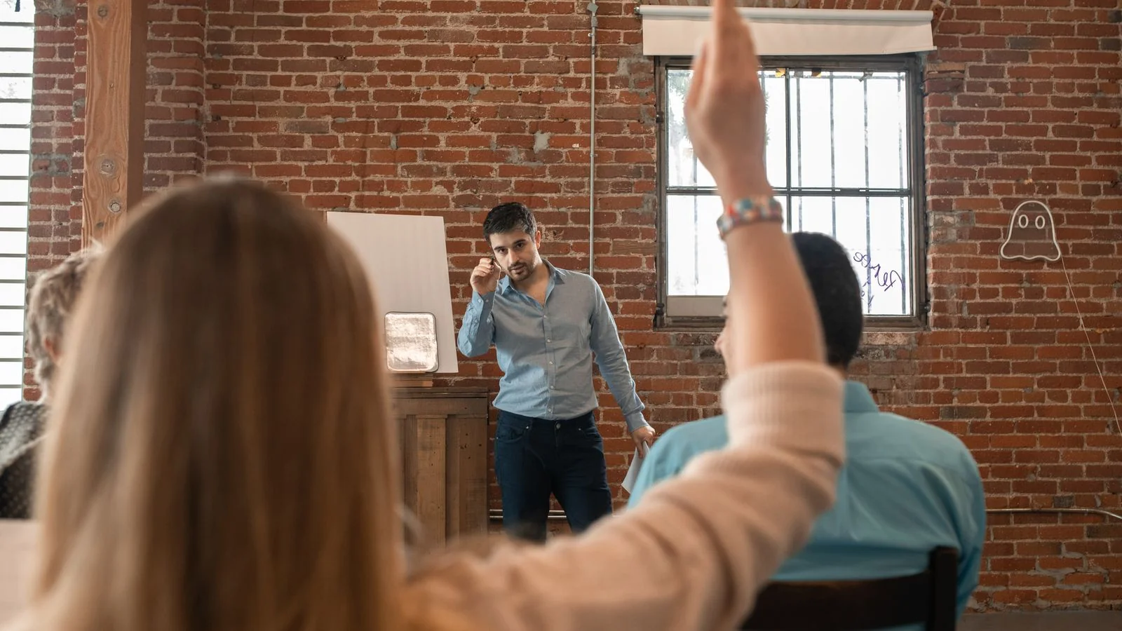 A teacher engaging with students in a classroom, the format most community programming quietly resembles