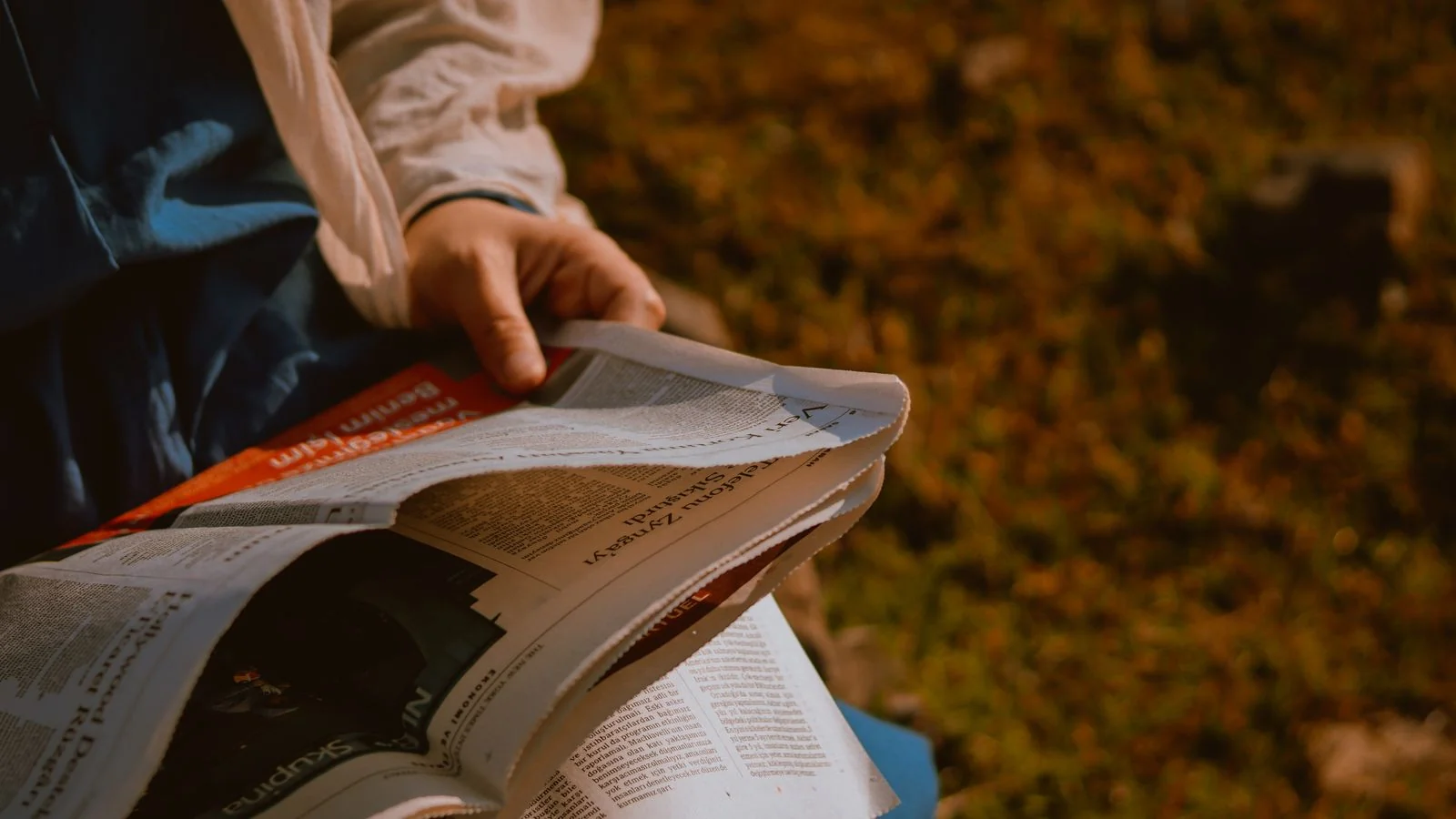 Reading a local newspaper.