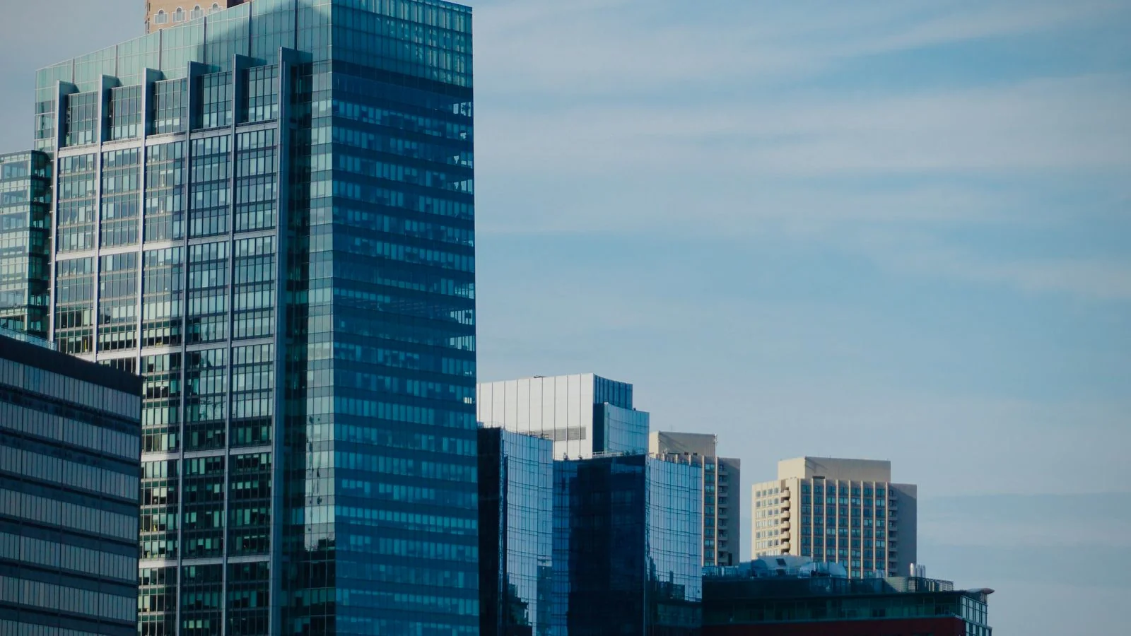 A modern city skyline of glass towers, where the buyers of executive coaching sit