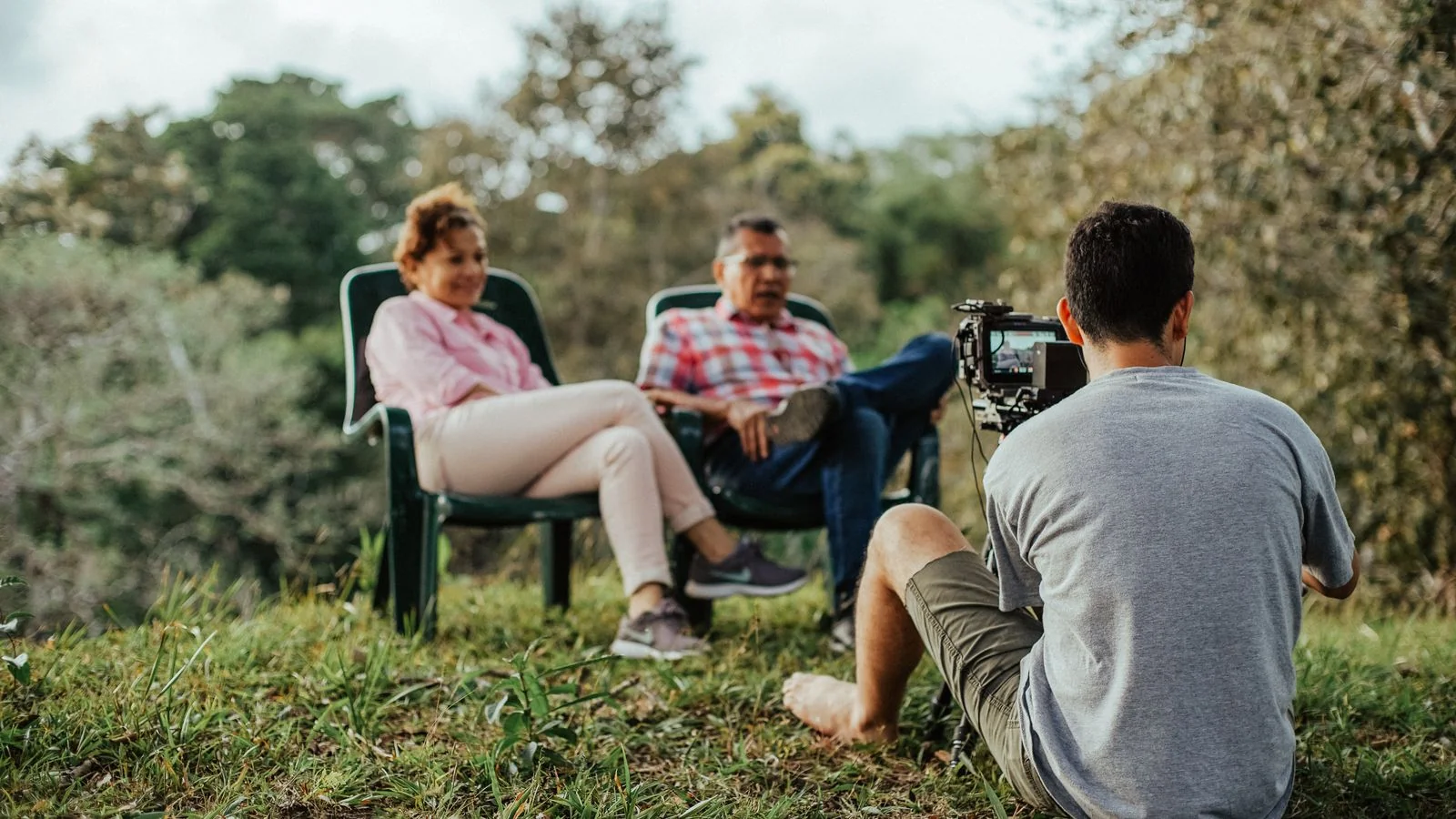 A couple being interviewed outdoors by a photographer, the kind of human-interest framing local reporters want.