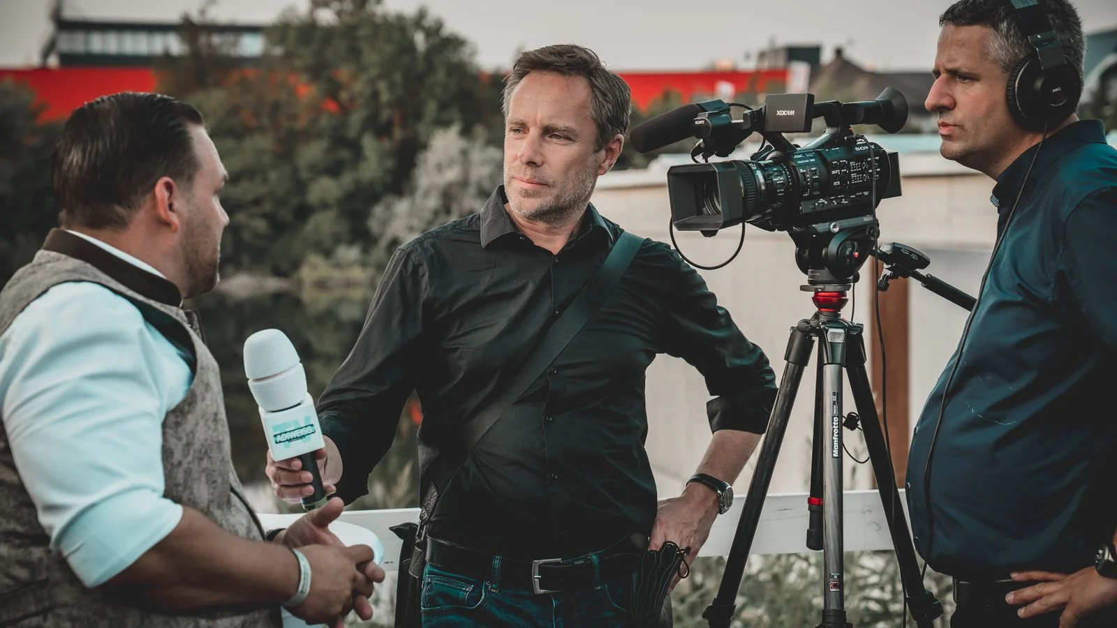 A news crew running an on-camera interview outdoors, the coverage a good pitch can earn.